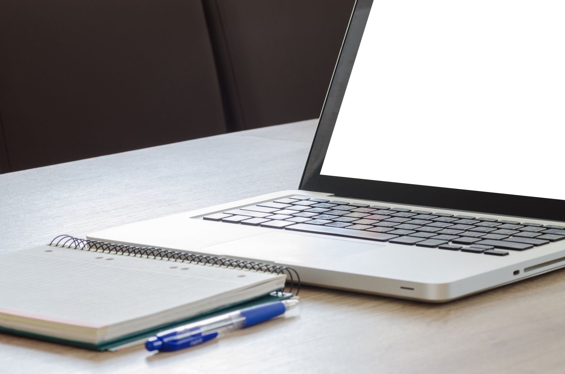 a laptop screen displaying a creative writing prompt interface with a text refusal message visible, sitting on a wooden desk beside an open paperback novel