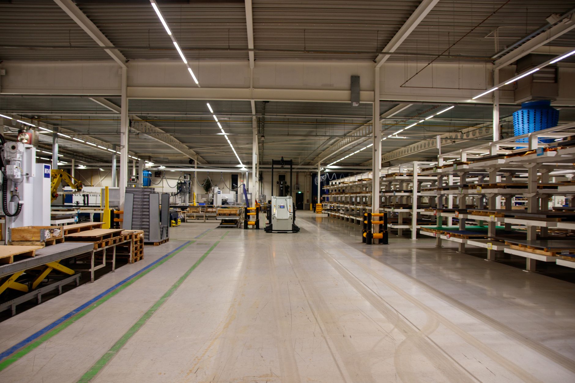 a large modern e-commerce fulfillment warehouse interior with conveyor belts and shelving units stacked with parcels under bright industrial lighting