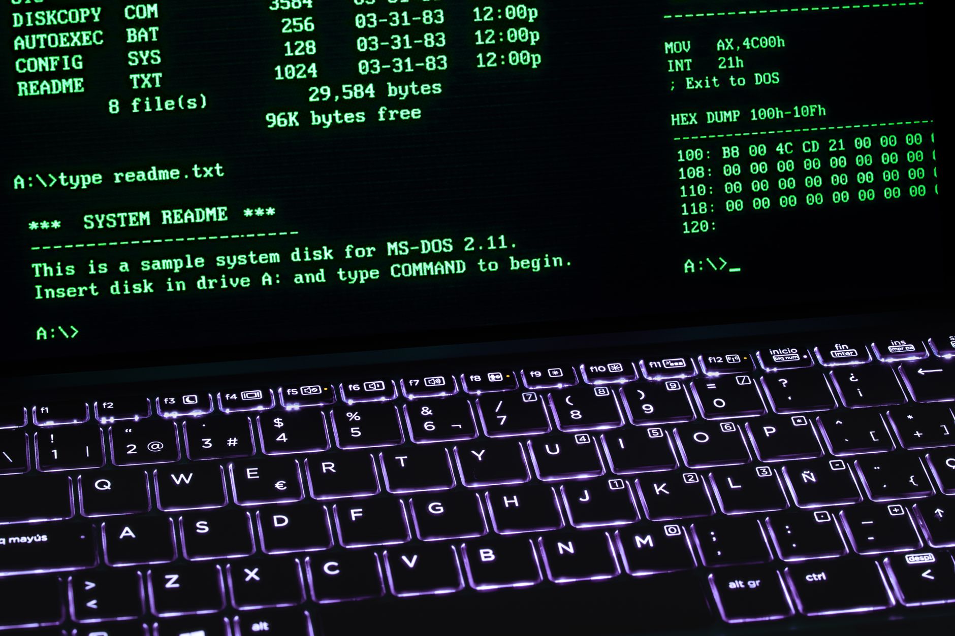 a close-up of a laptop screen displaying lines of code and network log output in a dark terminal window, with a mechanical keyboard partially visible in the foreground