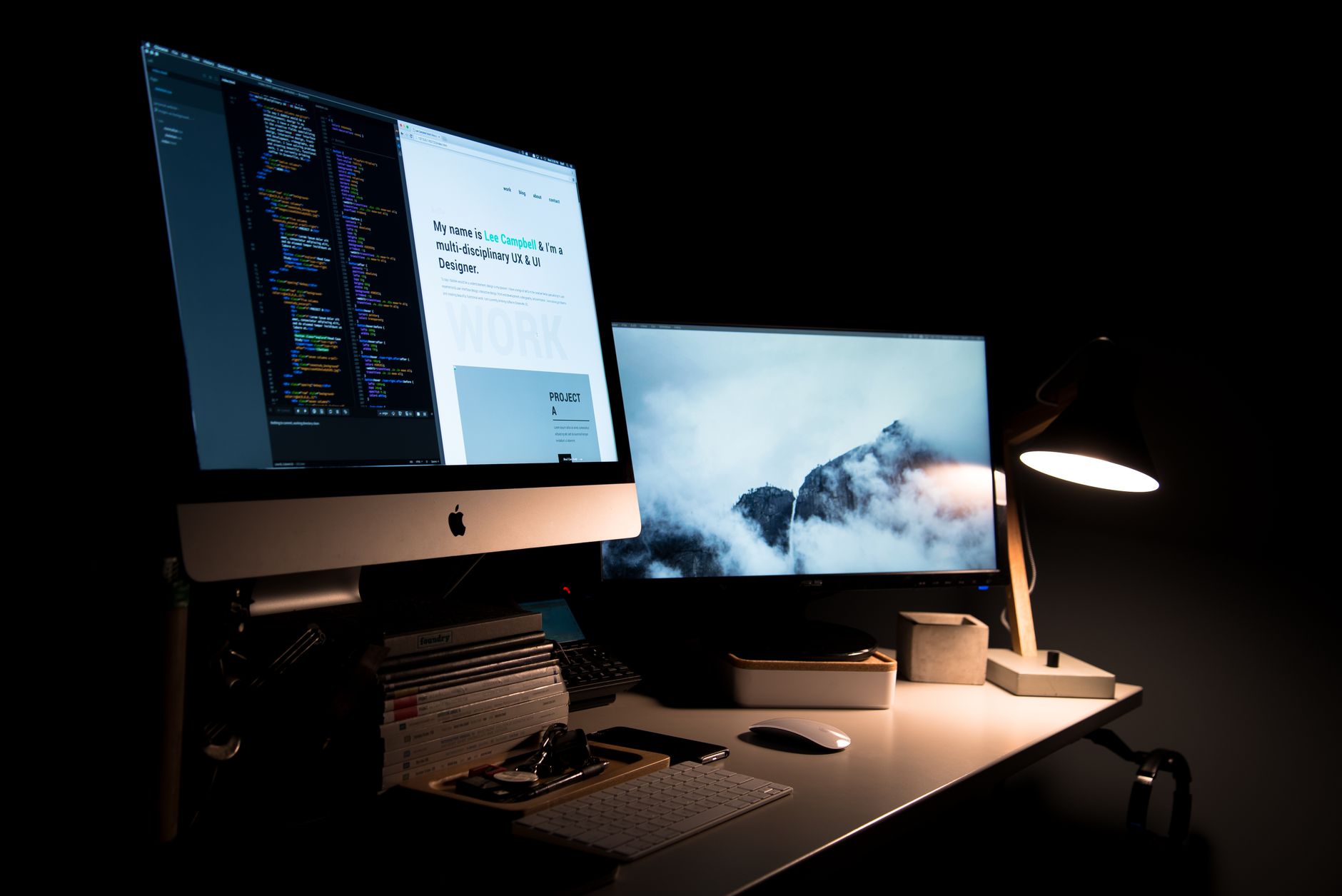a developer's multi-monitor workstation displaying an IDE with AI-generated code suggestions appearing in real time, keyboard and desk lamp in the foreground