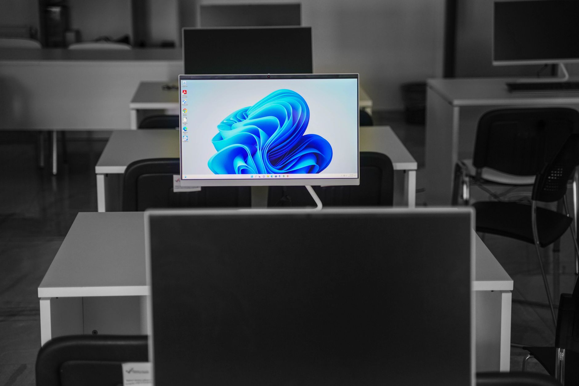 a wall-mounted monitor displaying a live enterprise AI workflow dashboard with task nodes and system status indicators in a modern office environment