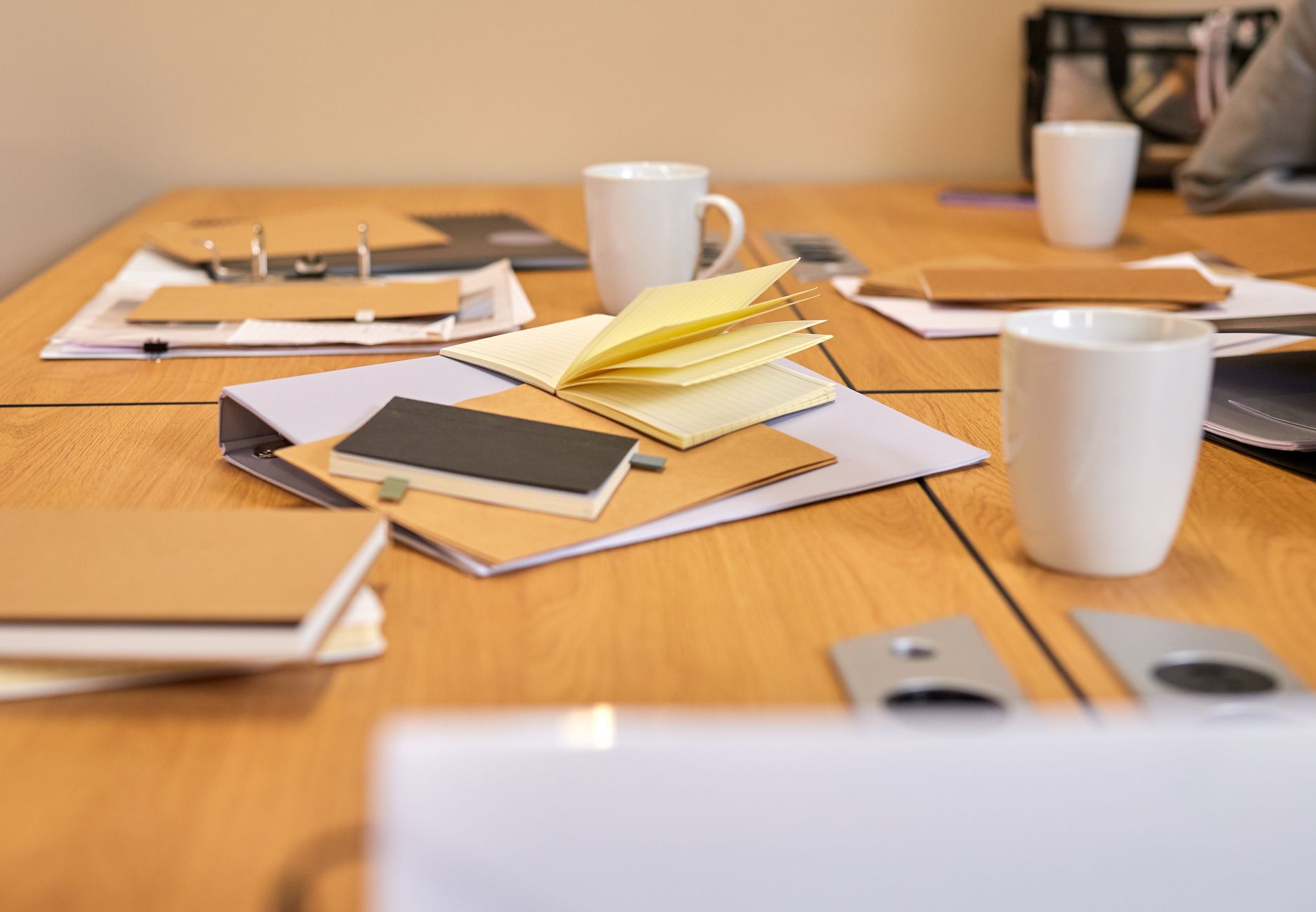 rows of legal documents and creative copyright filings spread across a large conference table beside a laptop showing a data dashboard with attribution tracking metrics