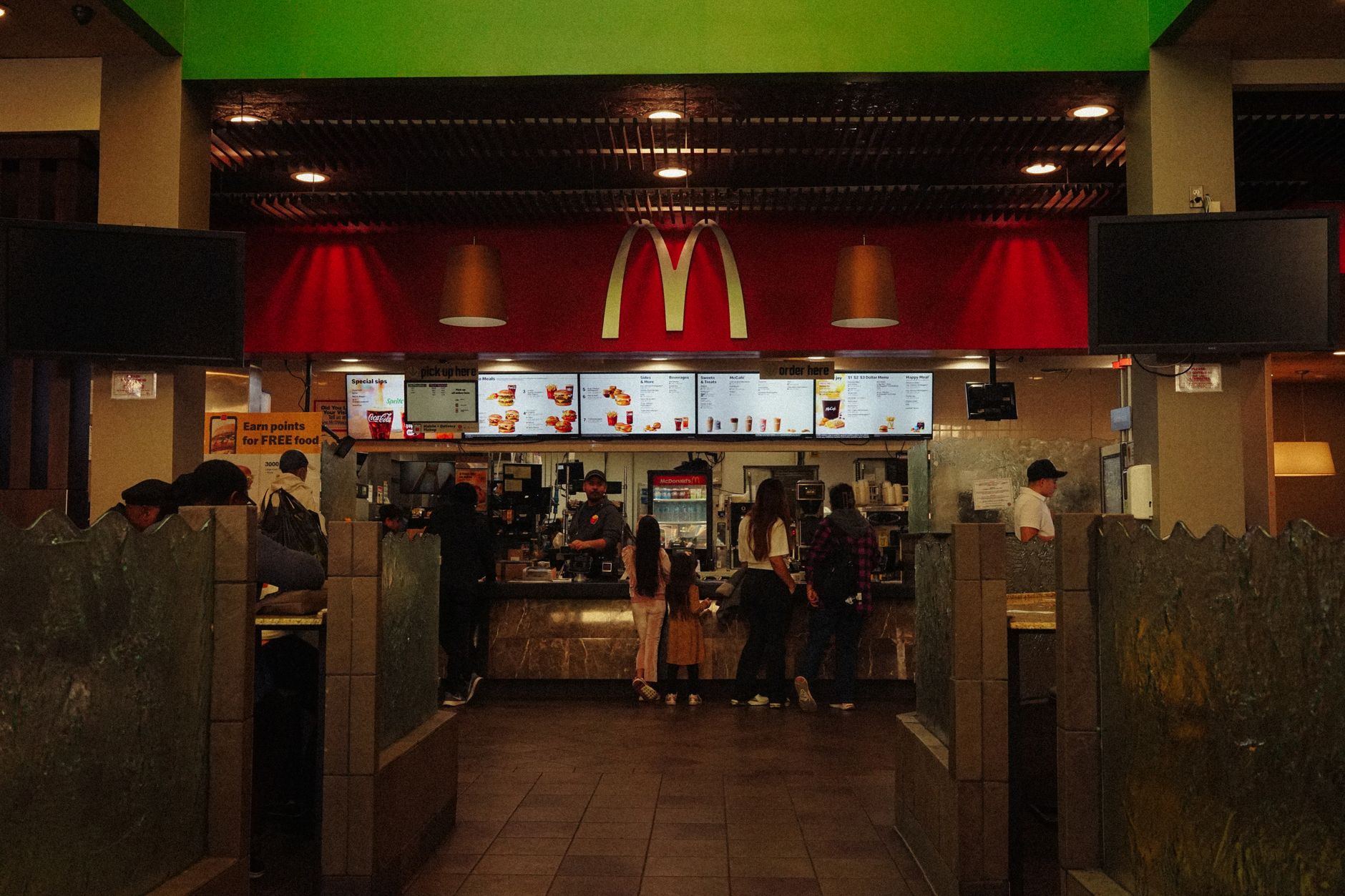 wide-angle interior of a large American travel center convenience store, showing rows of branded merchandise shelves and a deli counter under bright overhead lighting