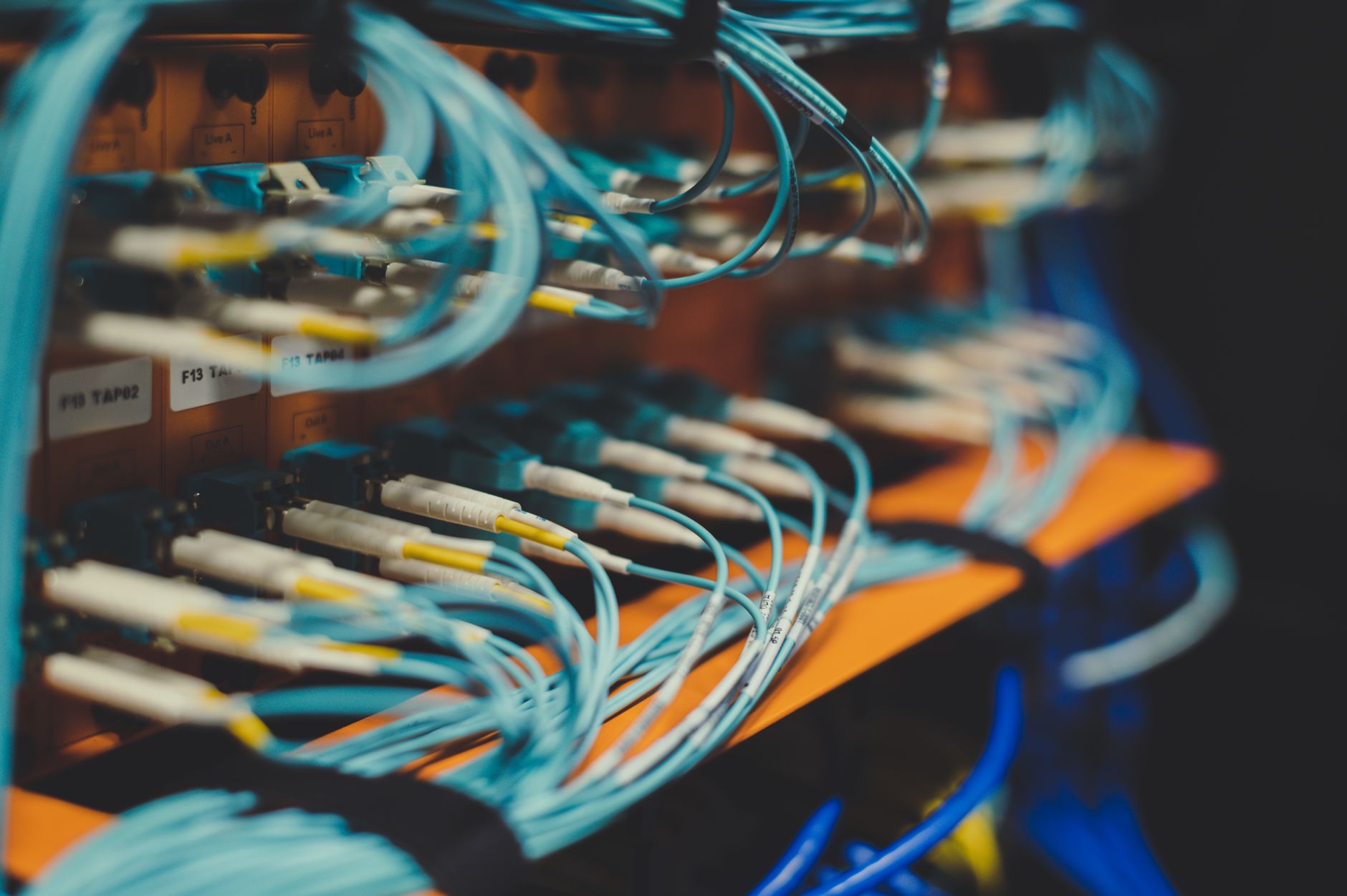 a close-up of a sleek enterprise security appliance mounted in a server rack, indicator lights active, in a dimly lit data center aisle