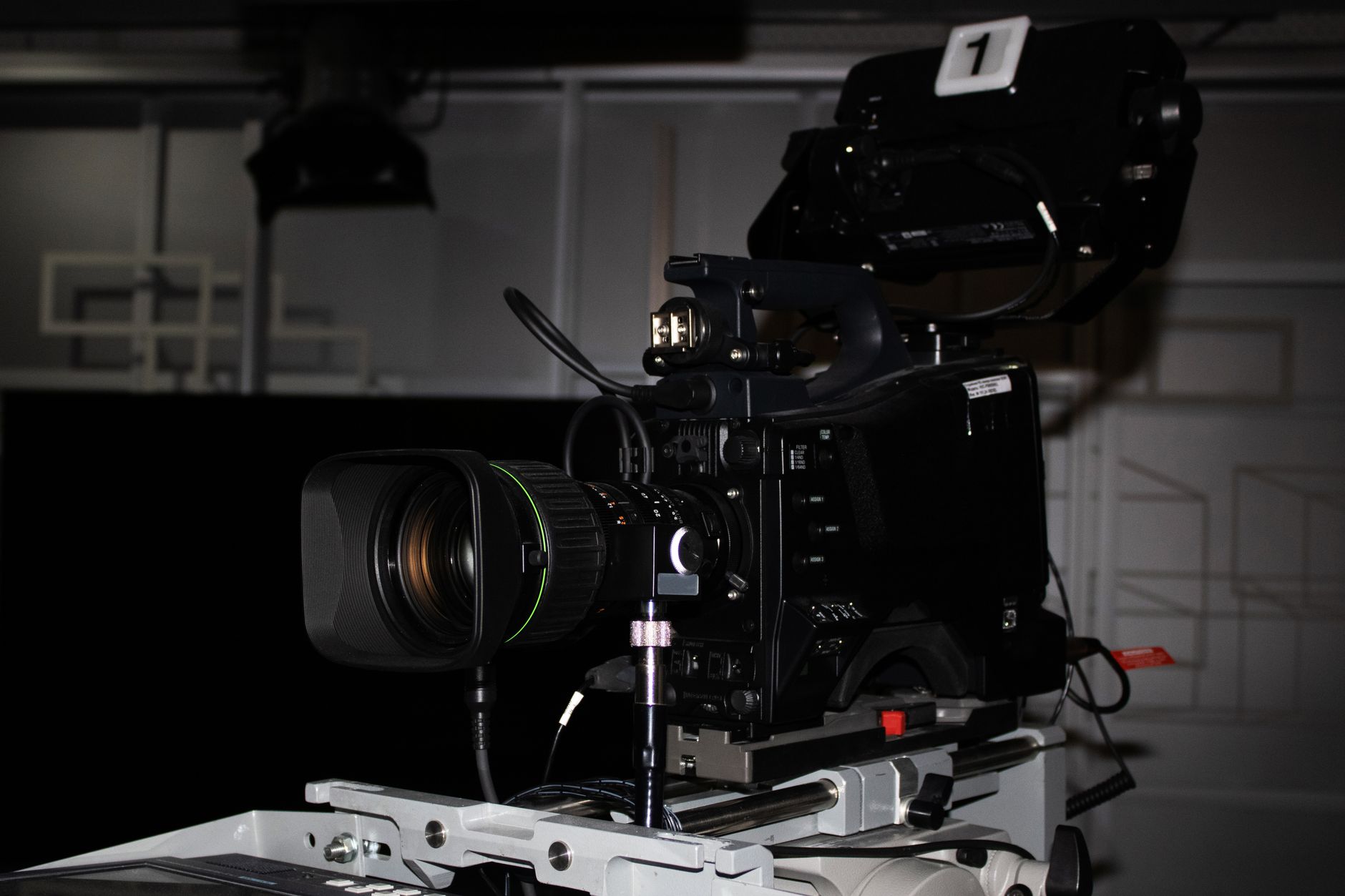 A high-resolution camera rig positioned directly above a single coin on a black velvet surface inside a controlled lighting enclosure, with no surrounding clutter