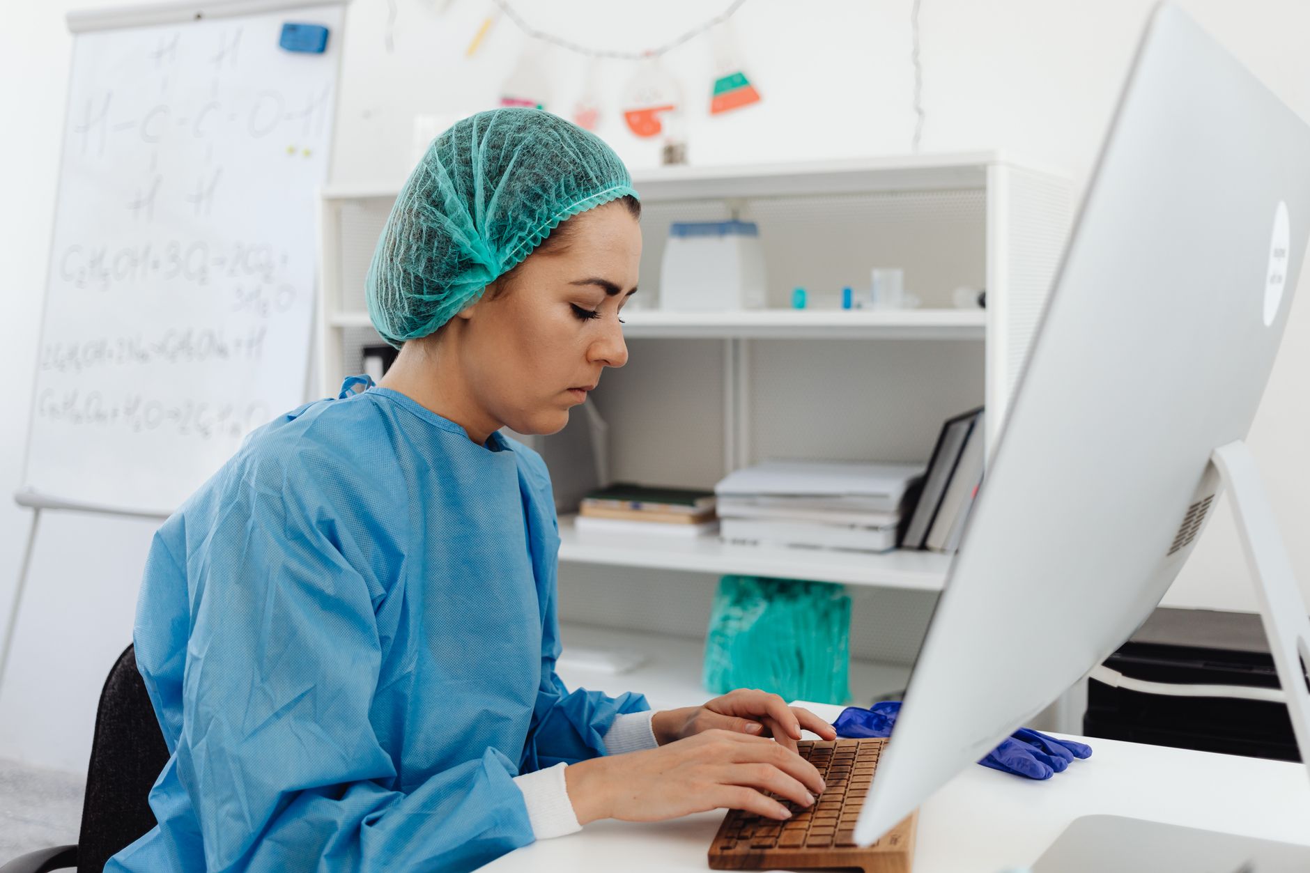 rows of electronic health record workstations in an empty clinical office, screens displaying structured data entry forms and scheduling grids
