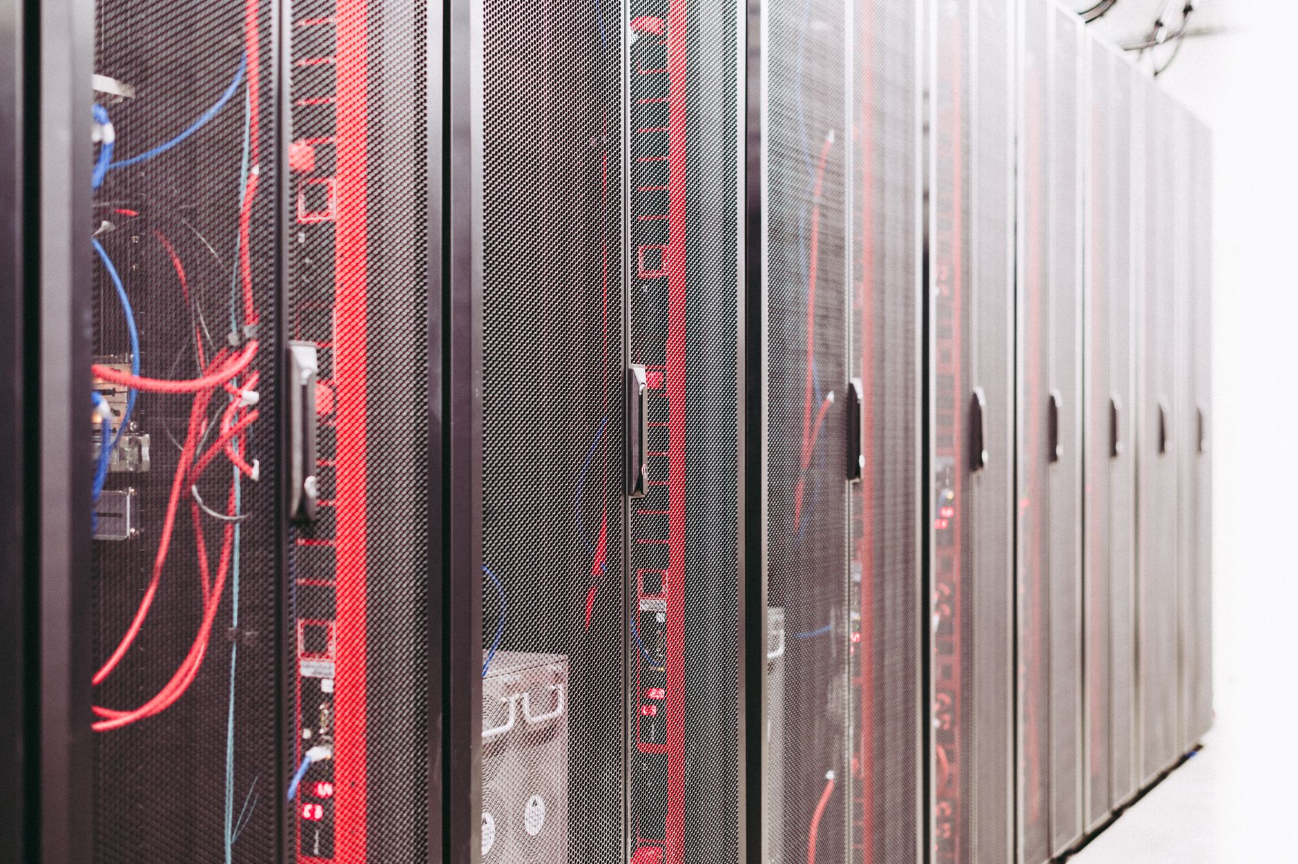 rows of climate simulation server racks inside a national weather service data center, with blinking indicator lights and dense cable management visible along the aisle