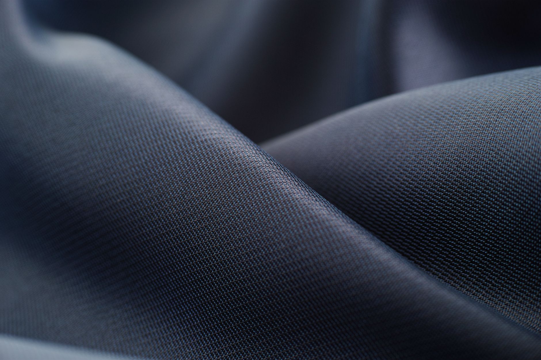 close-up of water beading on a tightly woven fabric swatch stretched across a laboratory testing frame