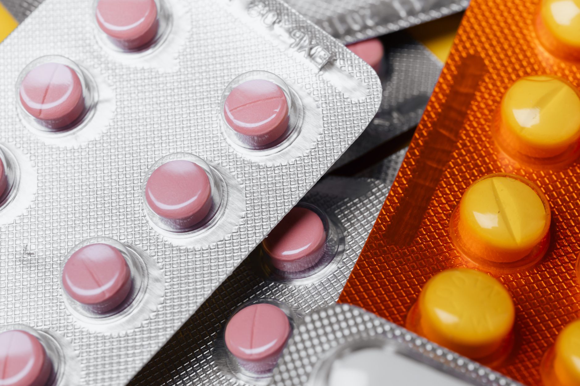 close-up of pharmaceutical blister packaging for oral tablet formulations arranged on a laboratory bench beside scientific notebooks and pipettes