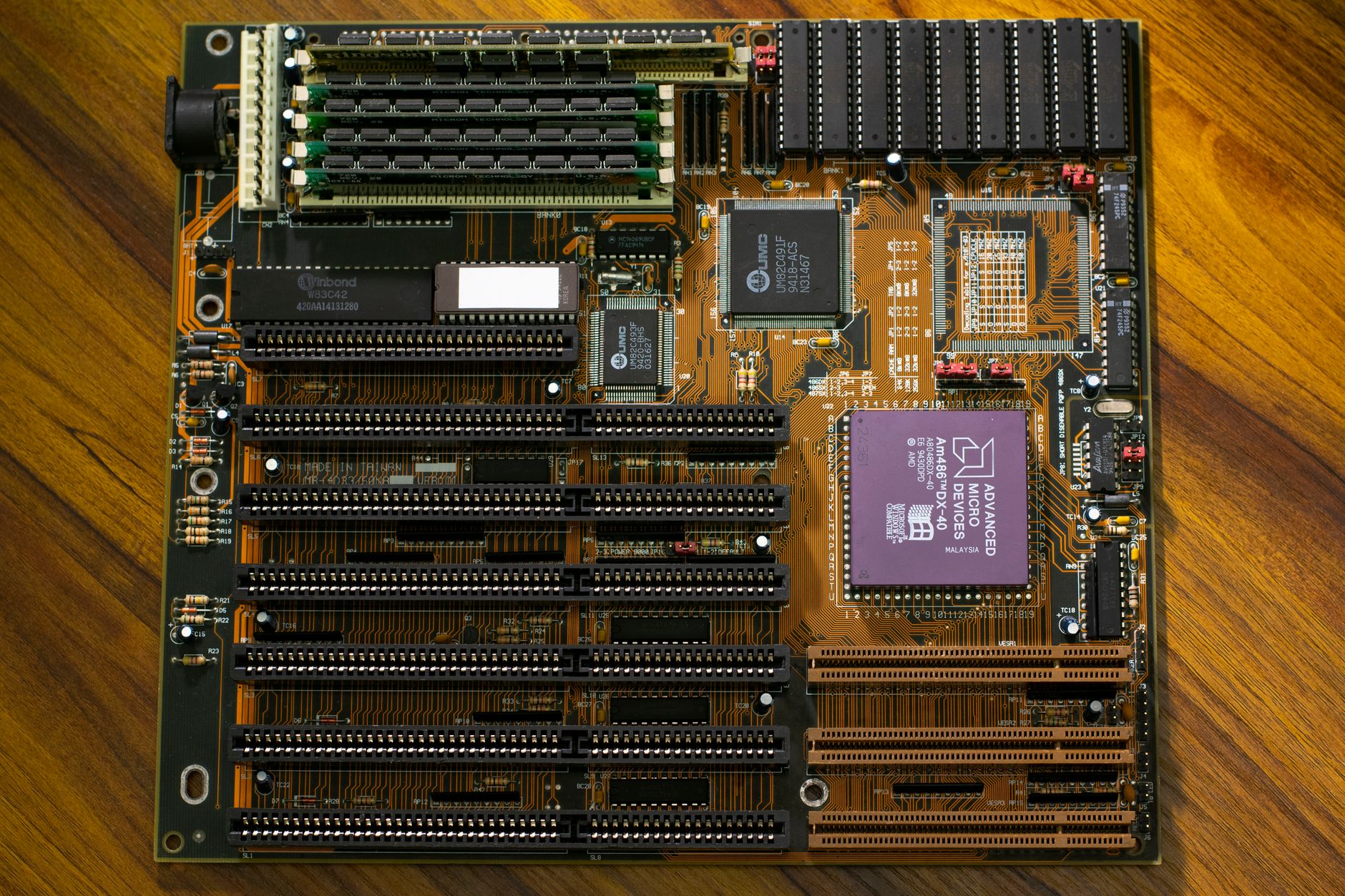 Close-up of an open Framework Laptop 13 showing the exposed motherboard and modular expansion card slots on a wooden desk
