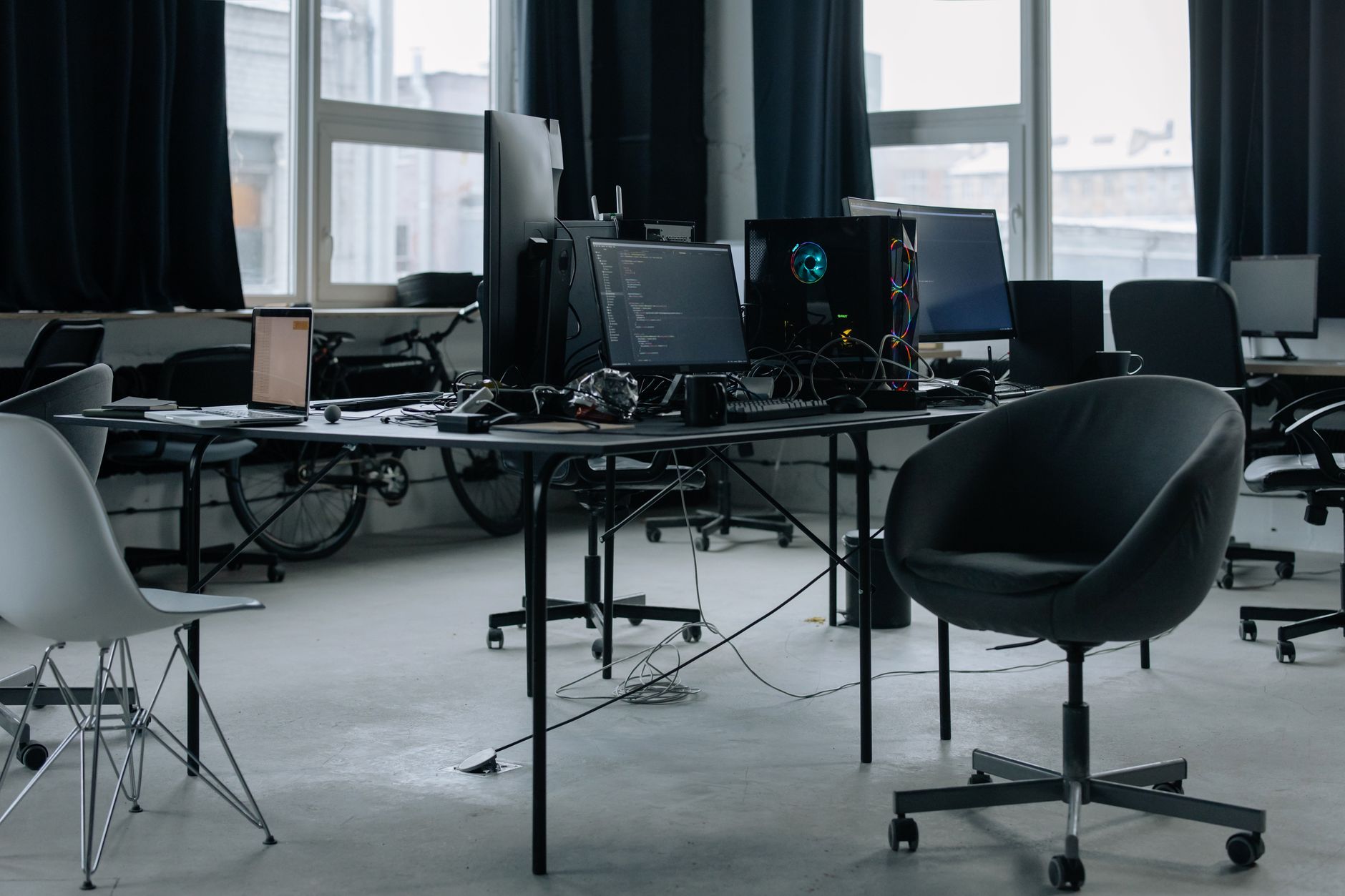 a wide-angle view of a modern open-plan tech office at late afternoon, empty workstations with monitors displaying structured document templates, warm light coming through large windows
