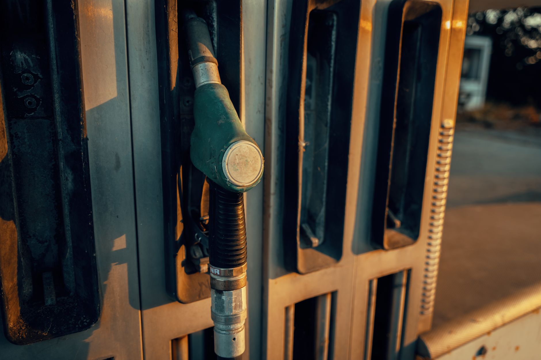 rows of portable gas detection devices charging in a docking station inside a utility company equipment room, industrial shelving visible in the background