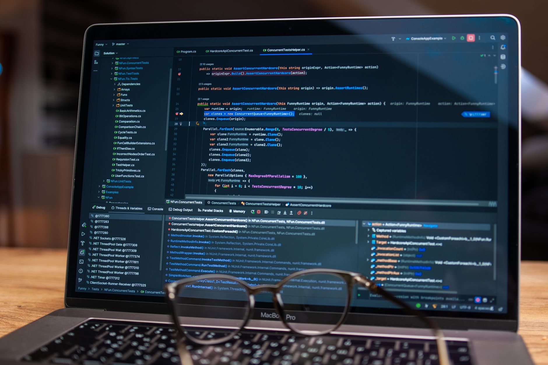 a startup open-plan office space with multiple monitors displaying code editors and AI development dashboards, soft natural light coming through large windows