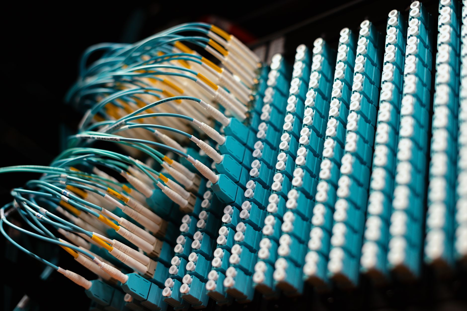 a government data center room in a modest building with rows of networking equipment and cables, natural light coming through a small window overlooking forested hills