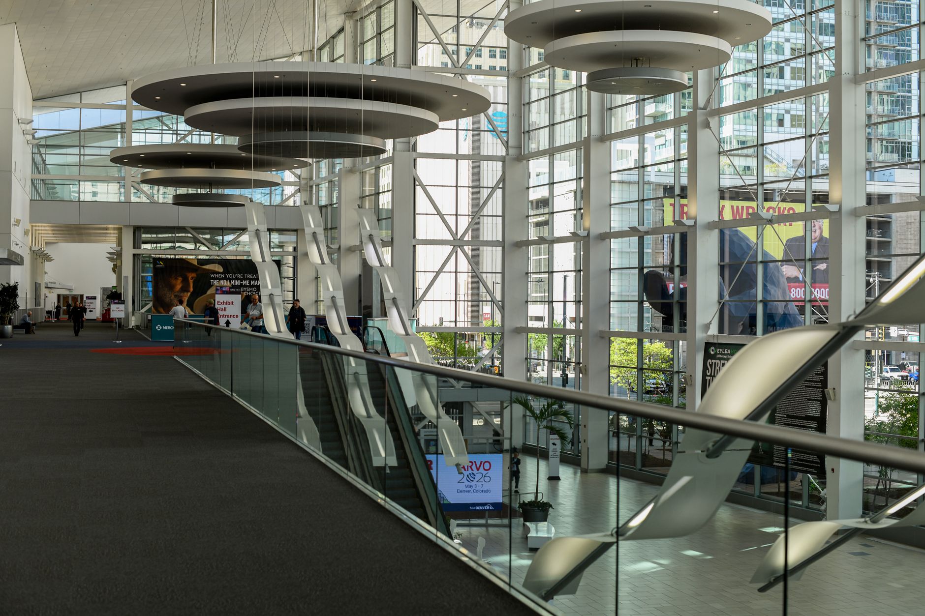 a sleek modern event registration area with badge holders on a table, soft ambient lighting, and abstract architectural details of a convention center interior