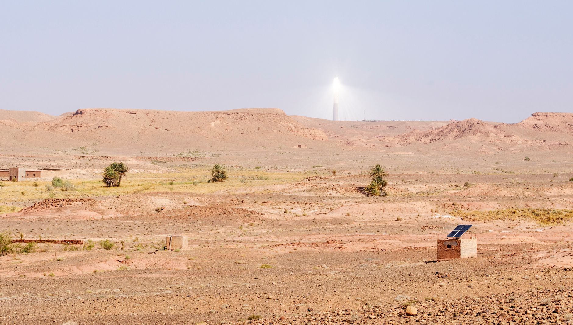 an outdoor missile defense battery installation in a desert landscape with launch tubes pointed skyward under a clear blue sky