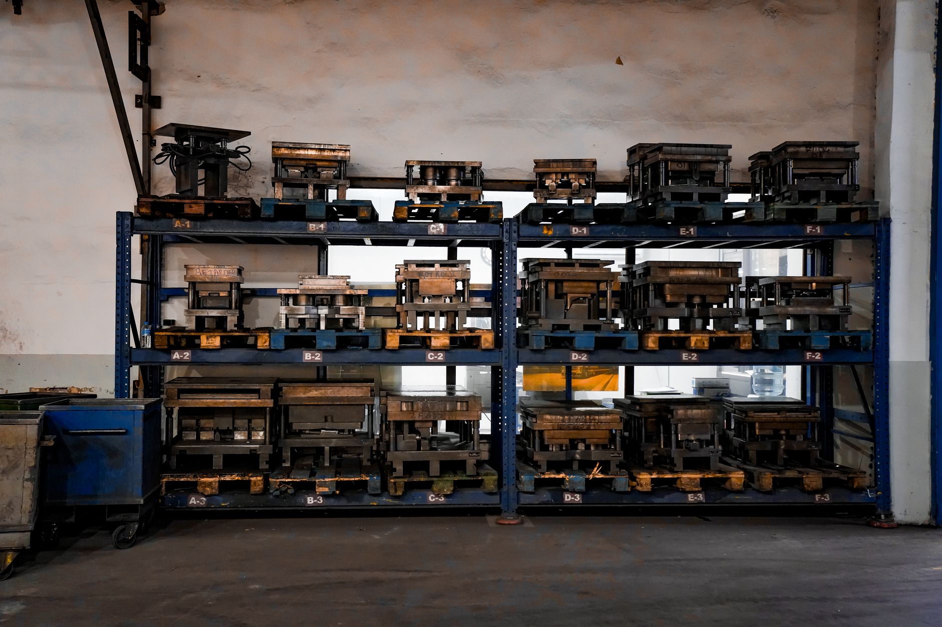 rows of military drone components laid out on a warehouse floor inside an Israeli industrial facility, shot from above