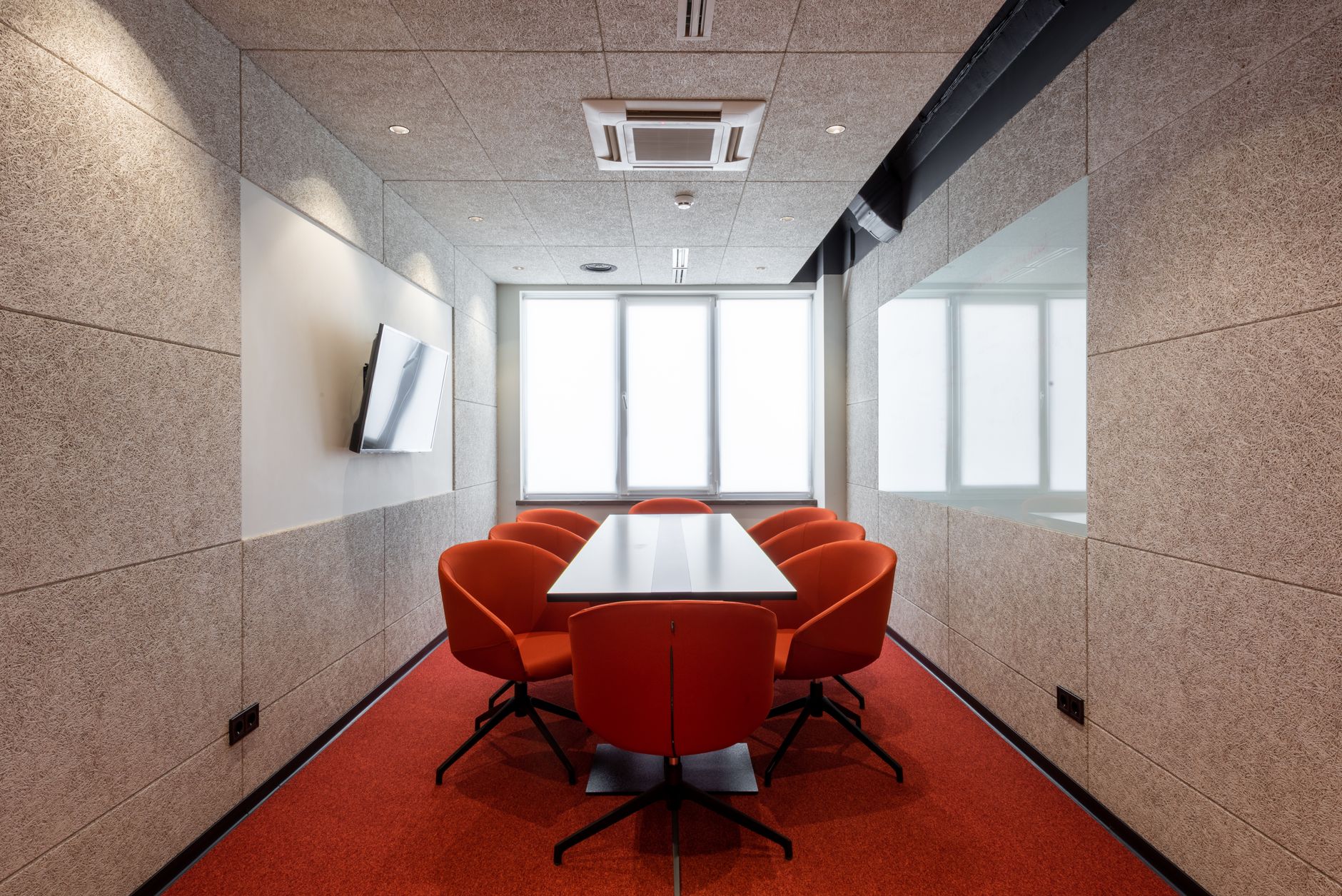rows of startup pitch boards and company name placards arranged along a conference room wall inside a modern innovation center, no people in frame