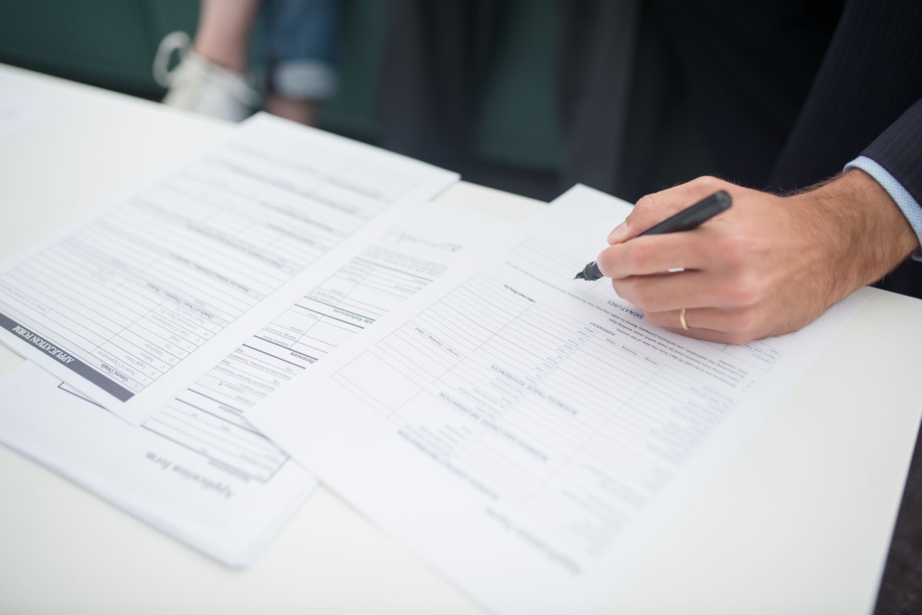 a stack of legal documents and financial prospectuses fanned out on a polished conference room table