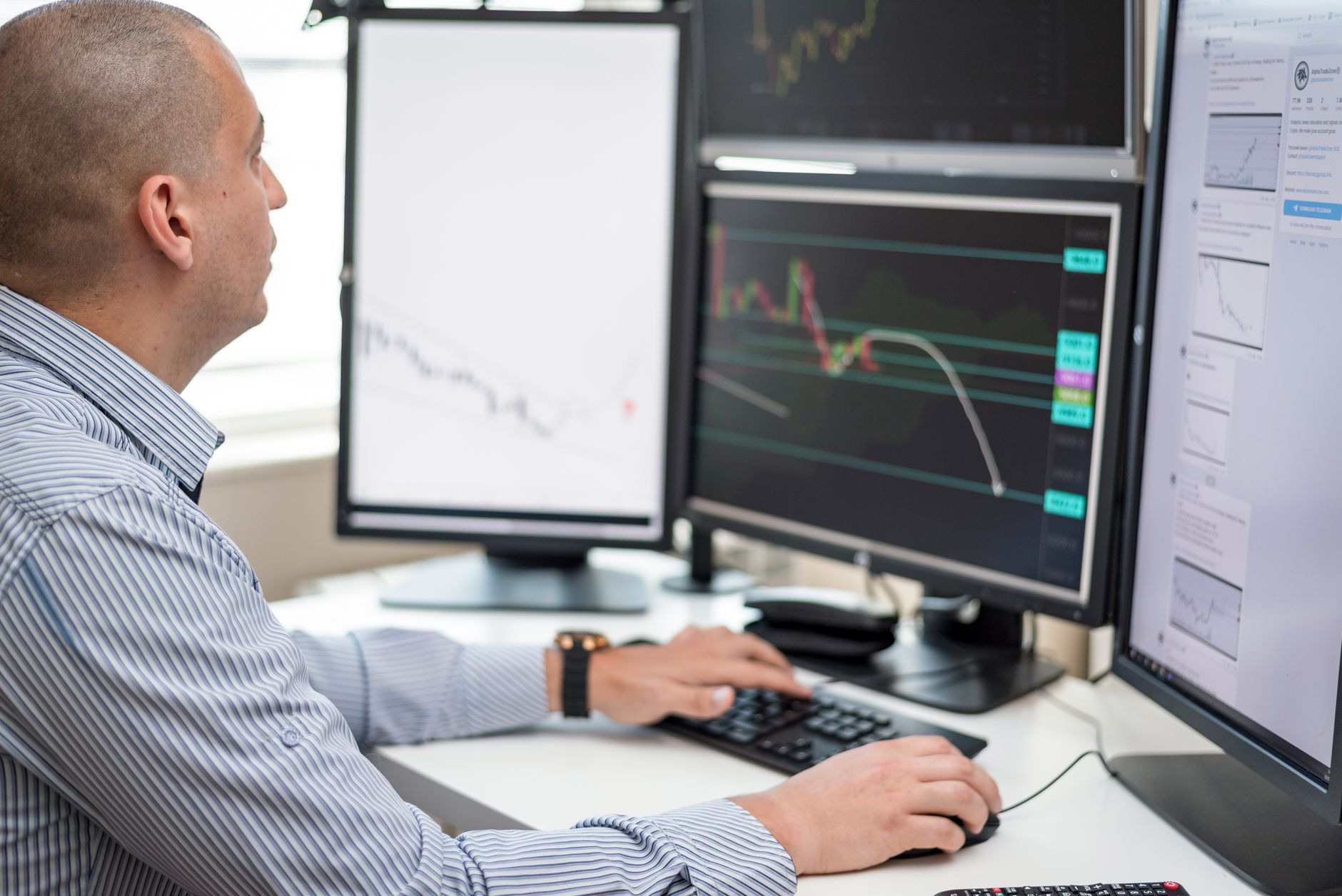 a desktop monitor displaying a financial dashboard with charts and a conversational query interface, photographed on a clean office desk with natural window light