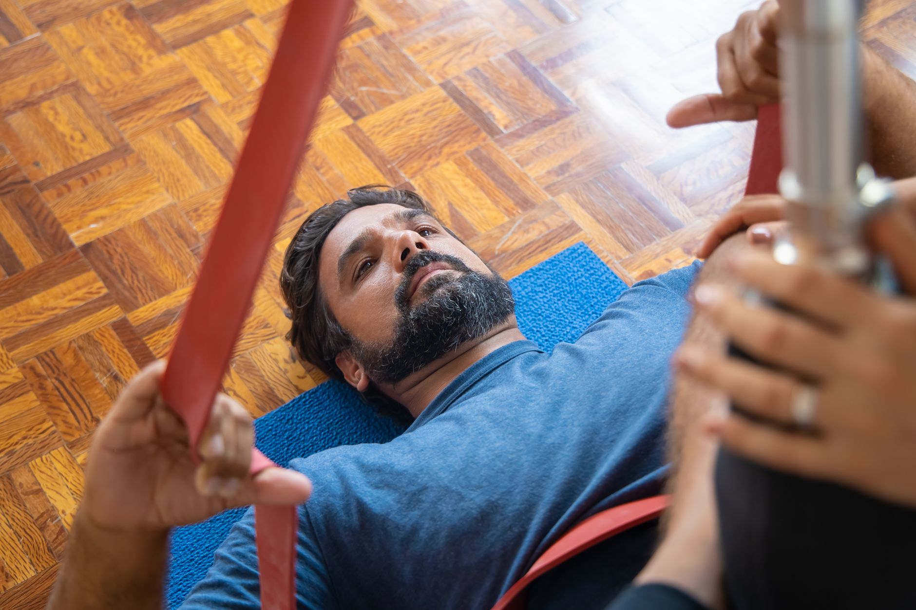 a home gym corner at dawn showing resistance bands, a pull-up bar mounted in a doorframe, and a foam roller on a hardwood floor