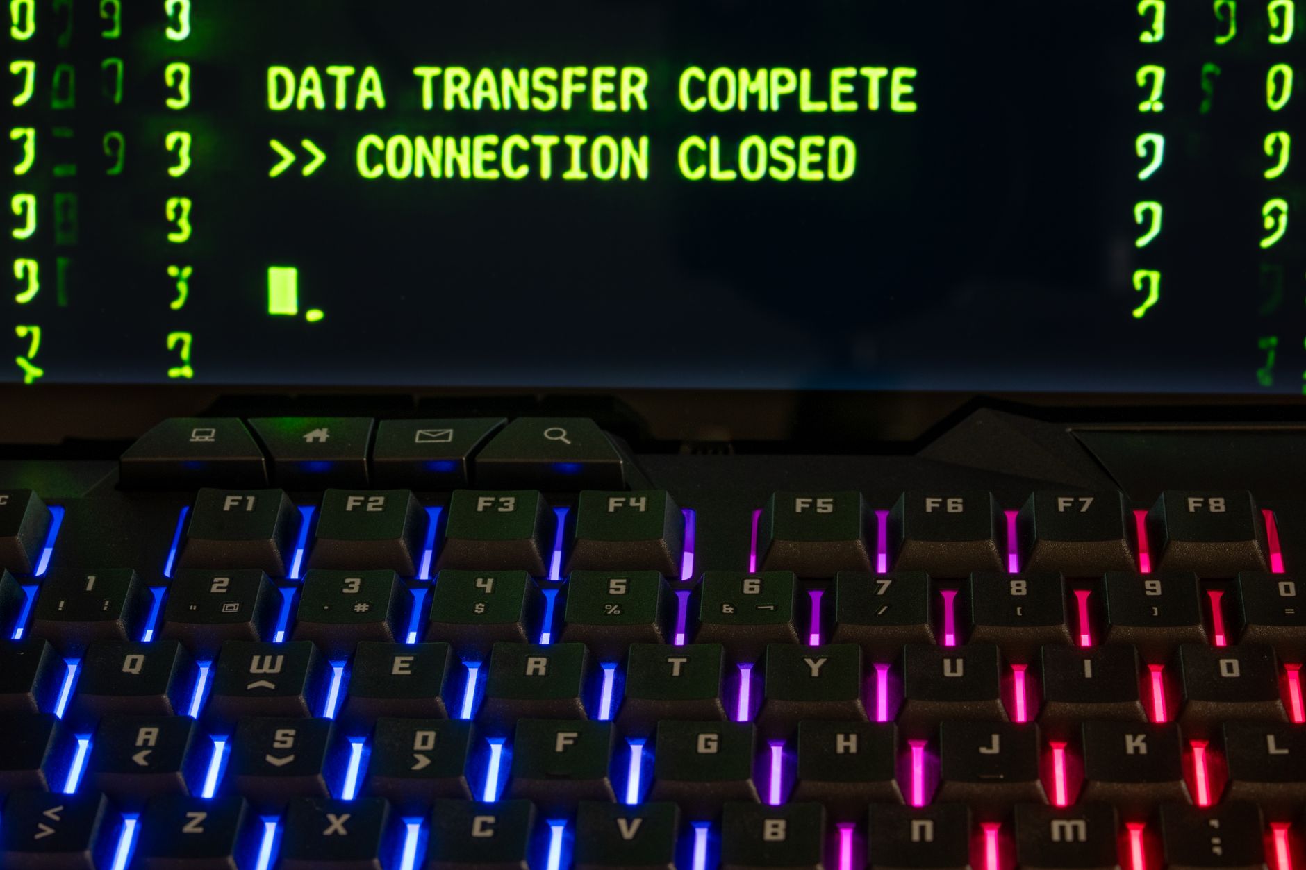 A high-resolution display showing a video generation interface with prompt text fields and rendered cinematic frame outputs on screen, set on a clean desk with keyboard and trackpad
