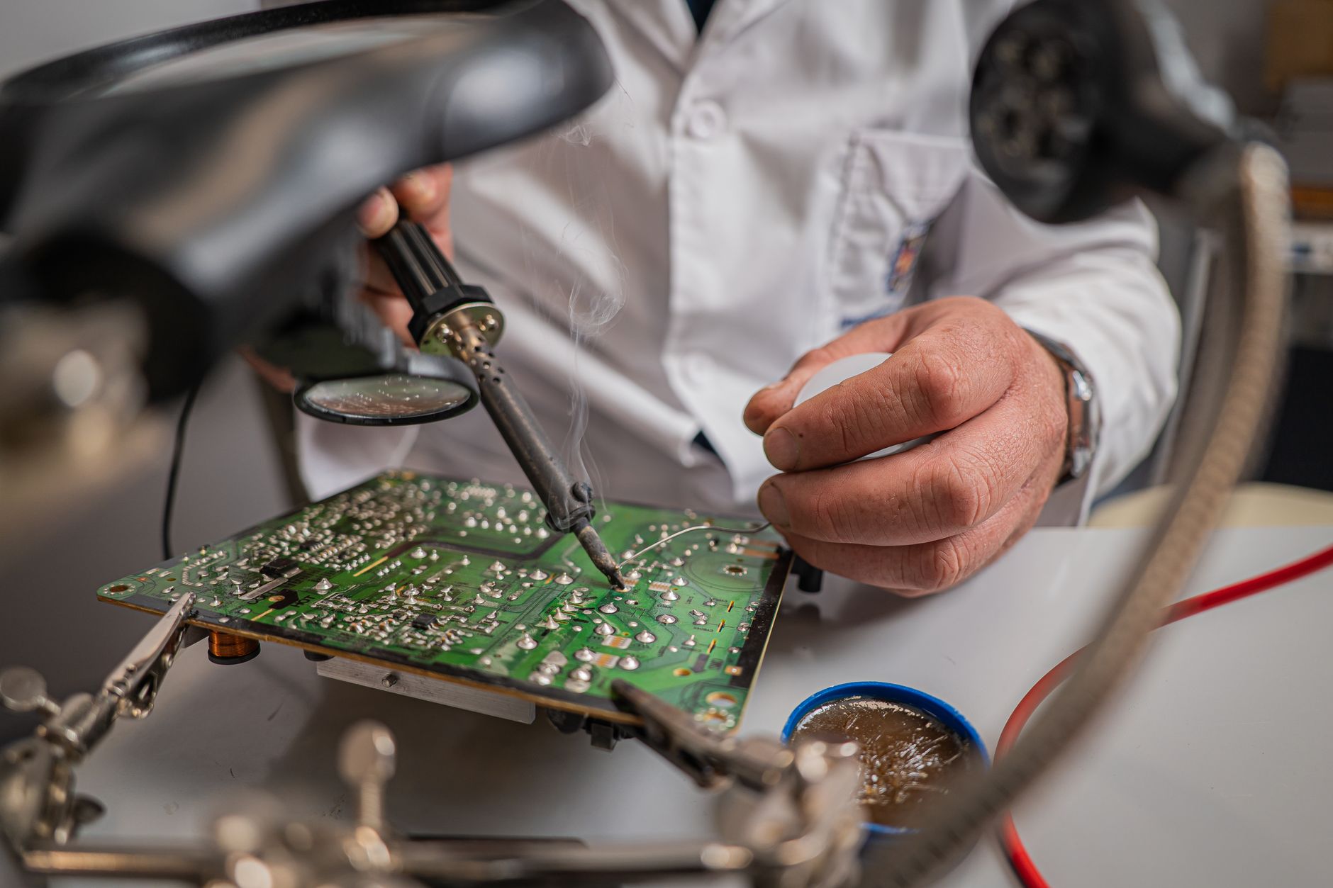 rows of ruggedized wireless communications modules and antenna arrays laid out on a workbench inside an electronics assembly facility