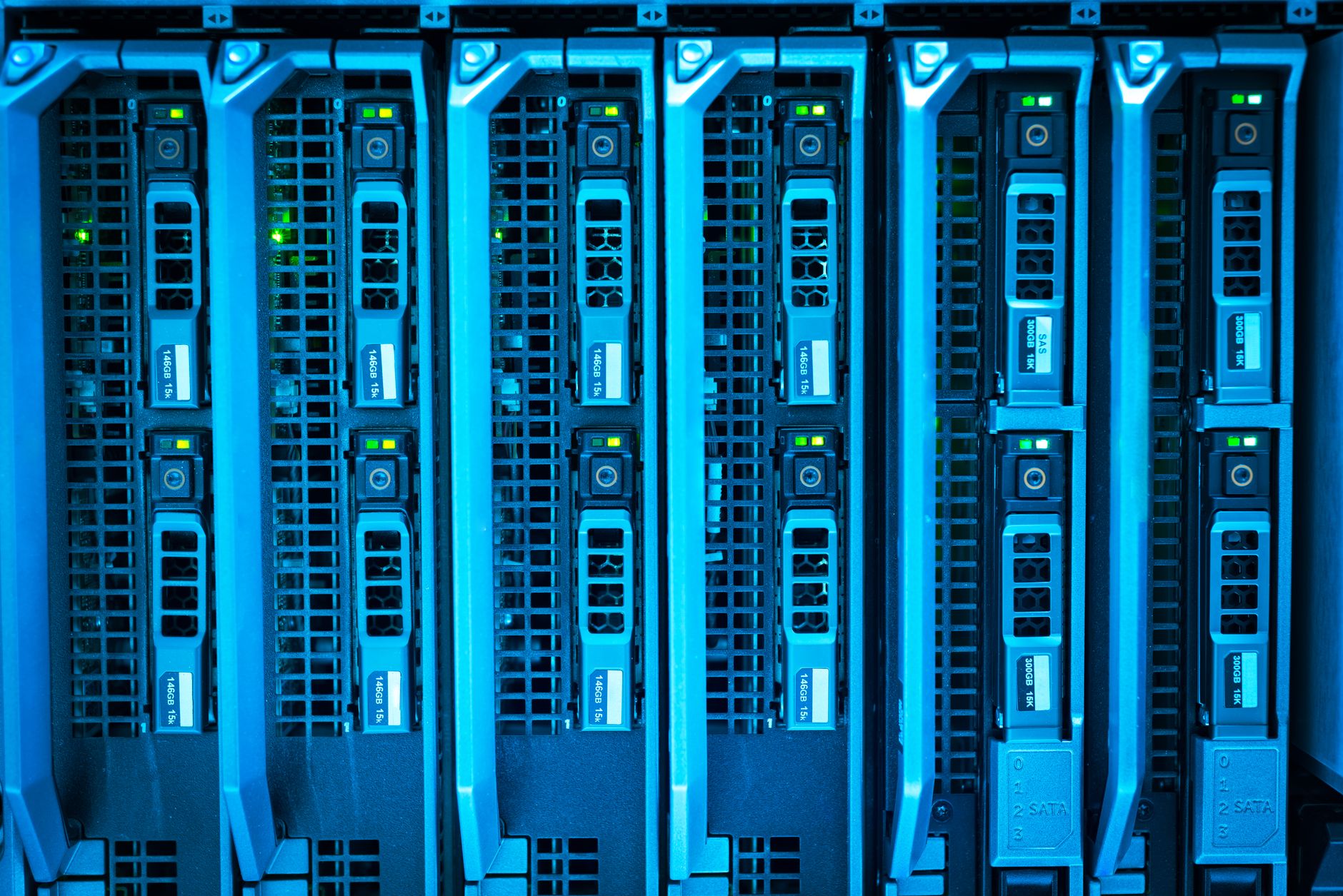 rows of high-density GPU server racks inside a large, dimly lit data center aisle with overhead cable trays and cooling units visible along the ceiling