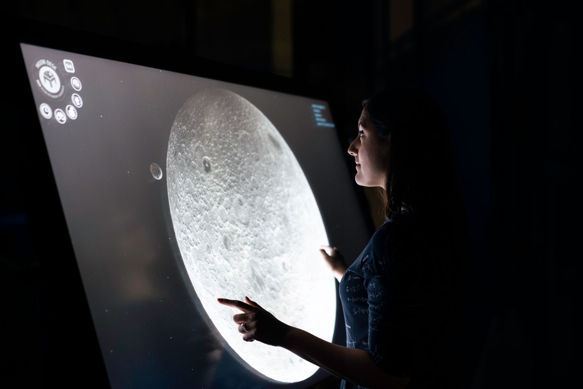 a large touchscreen interface displaying an AI task workflow diagram with branching decision nodes, set inside a dimly lit AI research lab