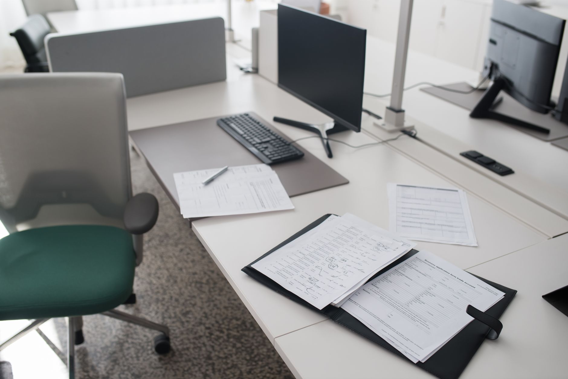 a sleek coworking office interior with monitors displaying legal documents and corporate registration forms, natural light coming through floor-to-ceiling windows