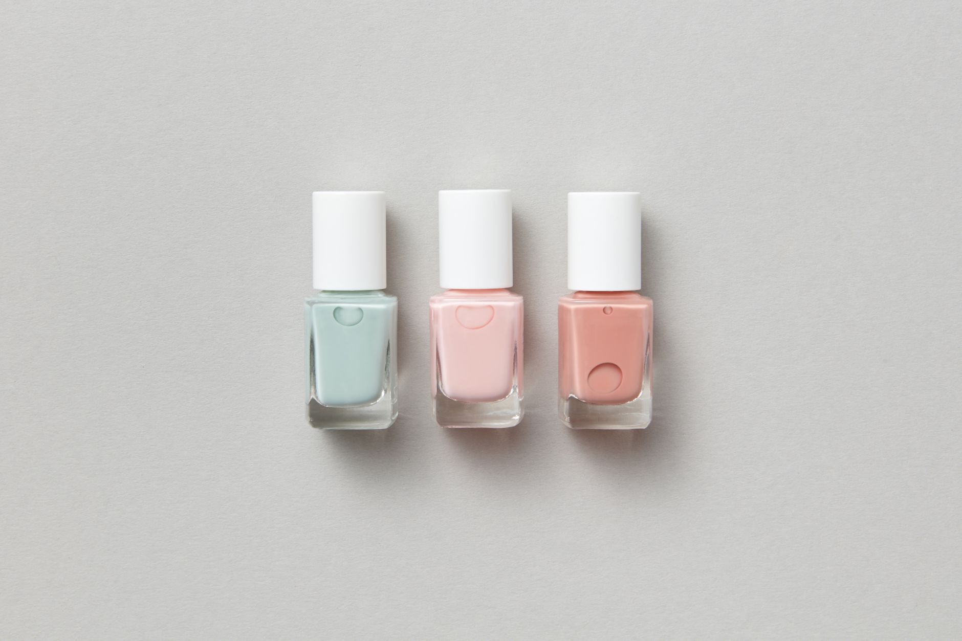 a minimalist product photography setup showing three generations of smart rings arranged on a gradient gray surface under studio lighting