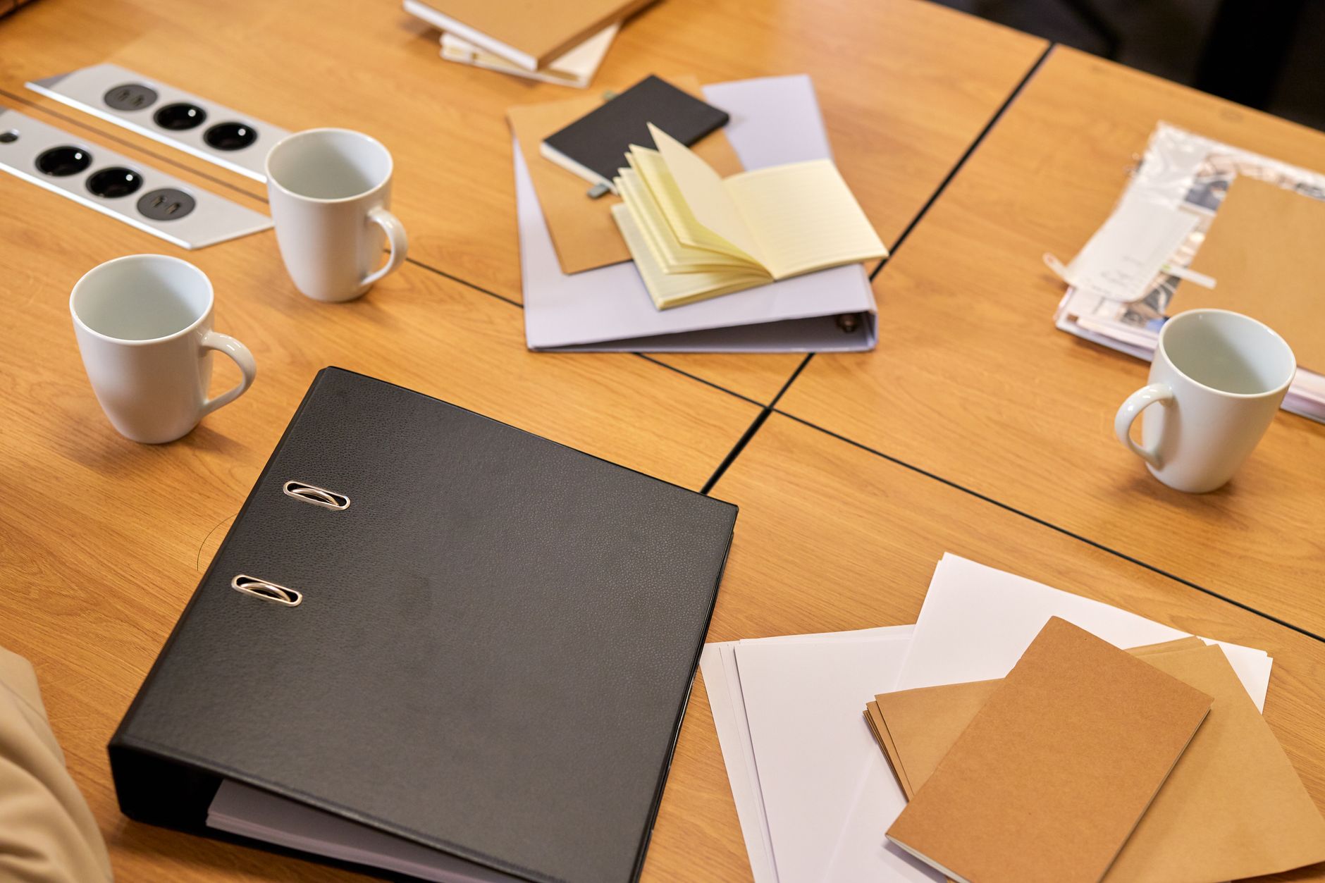 rows of legal document folders stacked on a wooden conference table inside a corporate law office