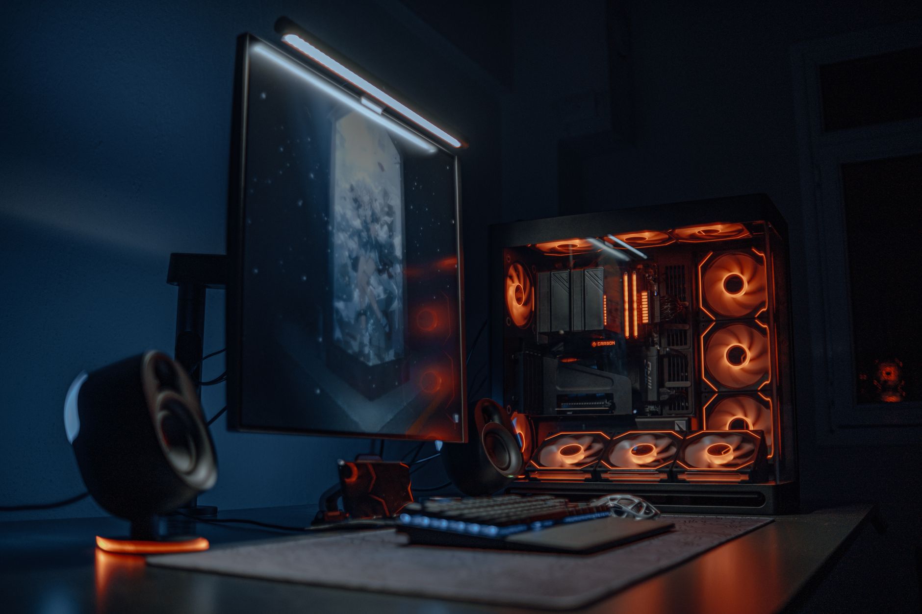 a compact desktop workstation with a high-end GPU card visible through a side panel window, sitting on a developer's desk beside a mechanical keyboard and multiple monitors displaying code
