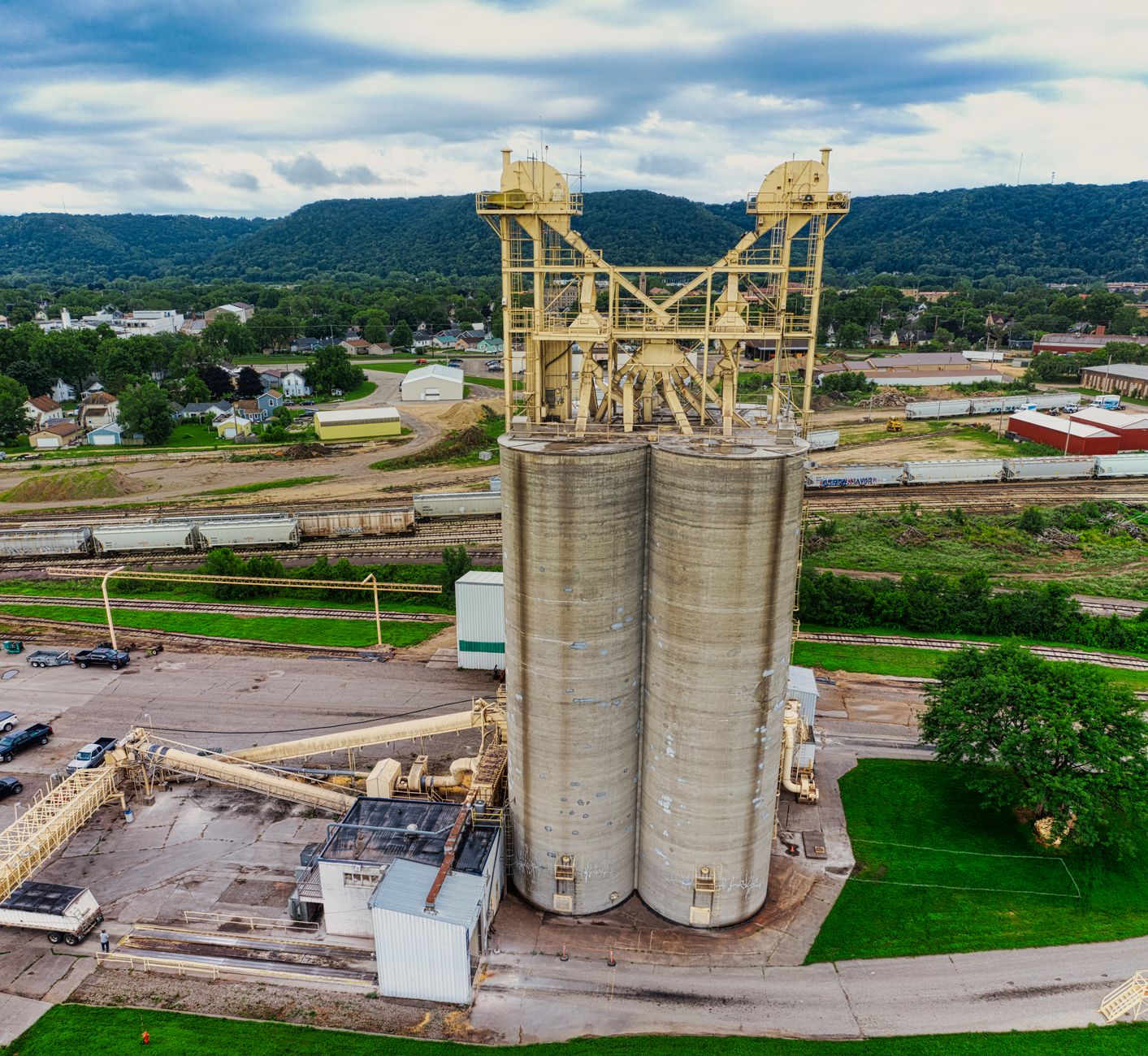 exterior view of a newly constructed industrial manufacturing facility surrounded by open land, with a drone prototype visible near a loading bay