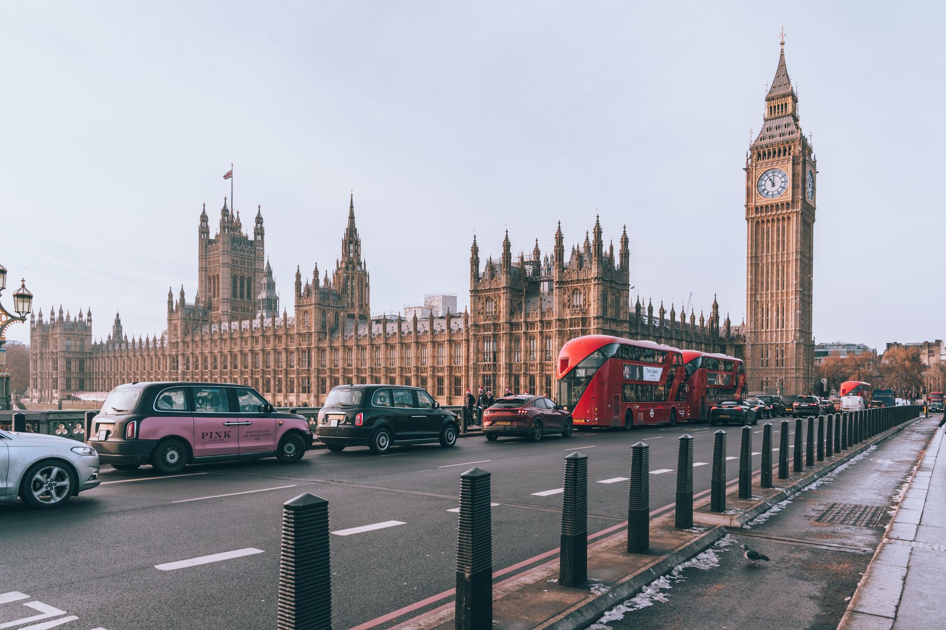 exterior shot of the London Stock Exchange building on a grey overcast morning, with taxis passing in the foreground