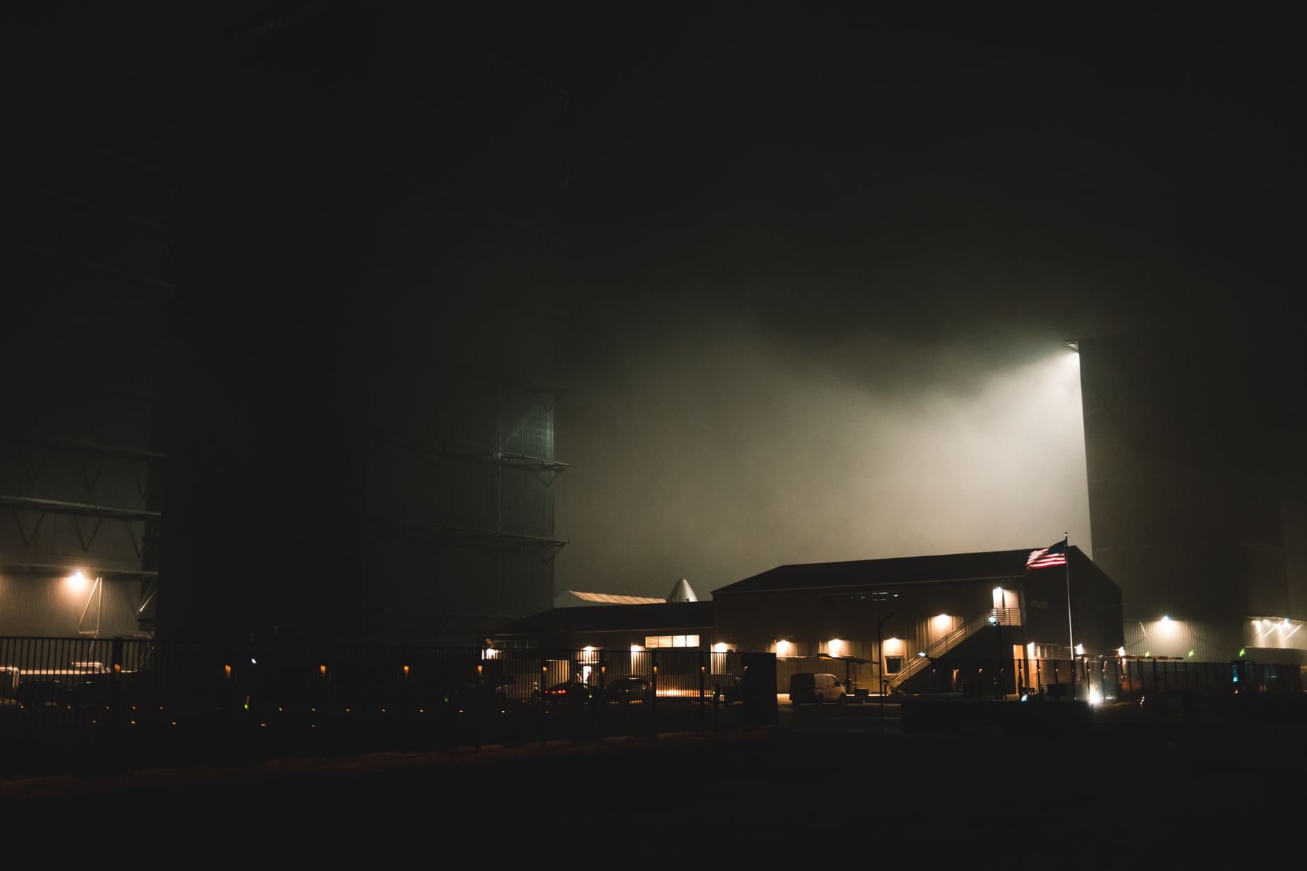 a commercial rocket launch pad at dusk with exhaust glow visible against a darkening sky, no text or logos present