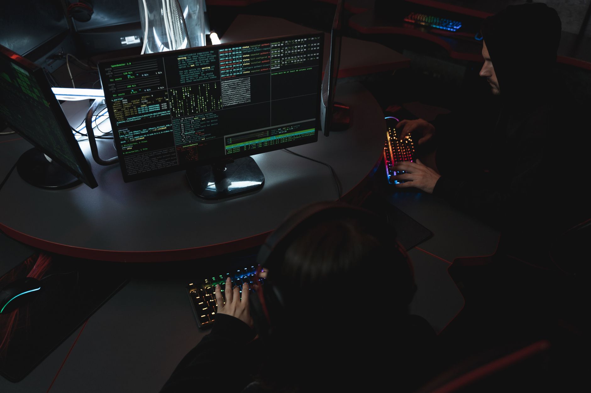a modern security operations center with multiple curved monitor arrays displaying network traffic dashboards and threat maps, lit by blue ambient lighting