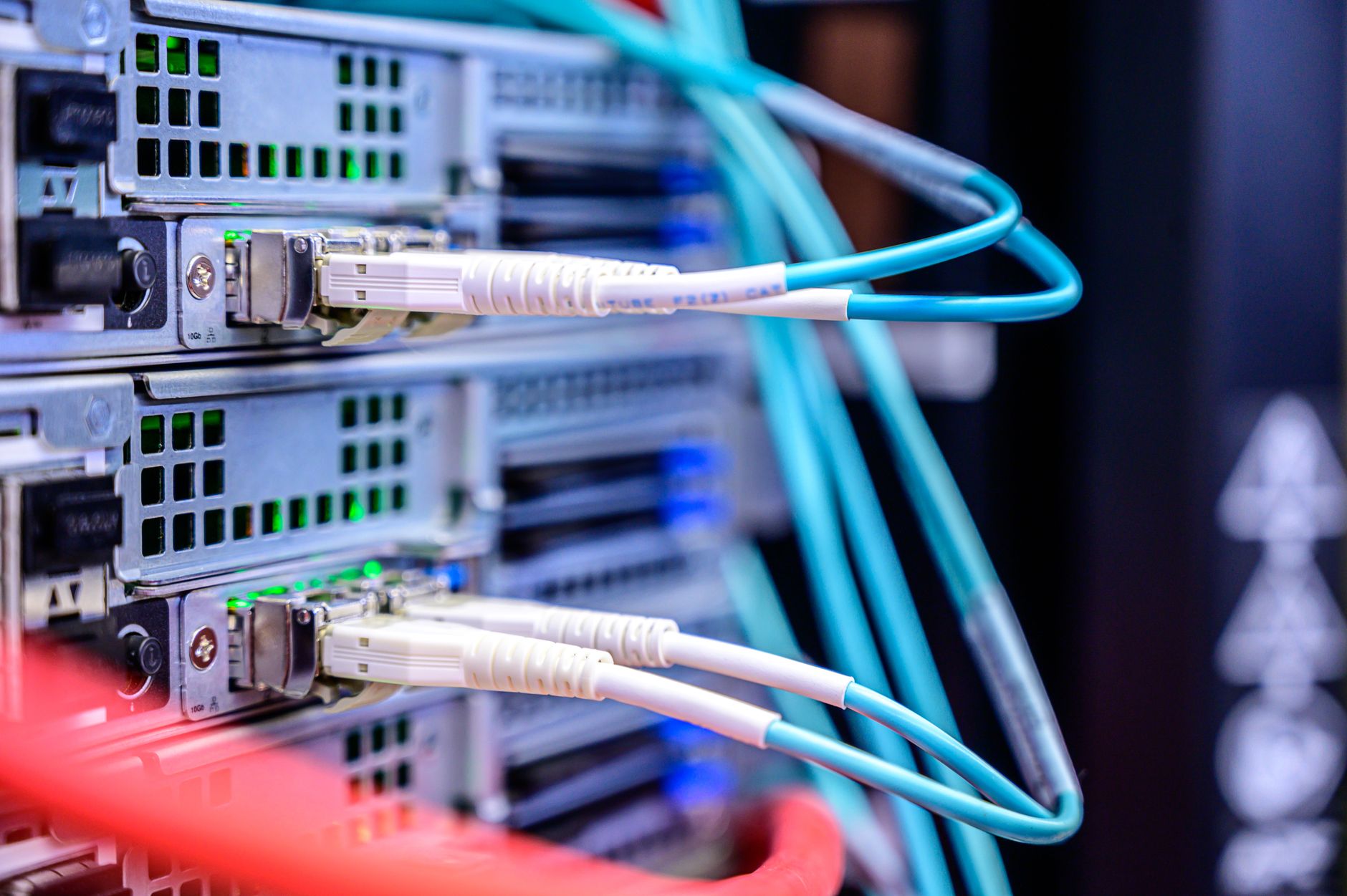 rows of rack-mounted network security appliances inside a government-adjacent data center, with structured cabling running overhead between metal cable trays