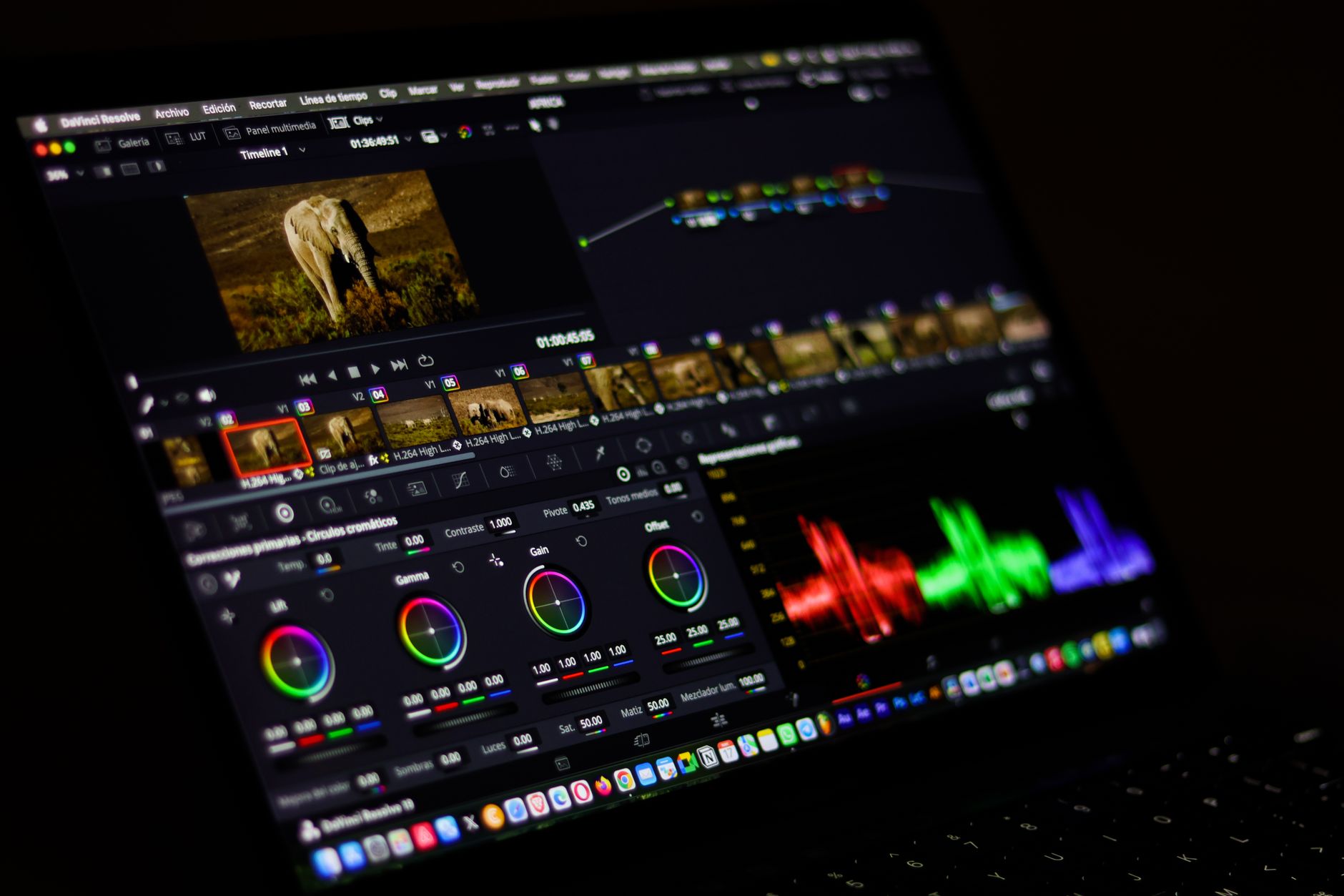 overhead view of a professional video editing workstation with multiple monitors showing timeline editing software and high-resolution cinematic footage