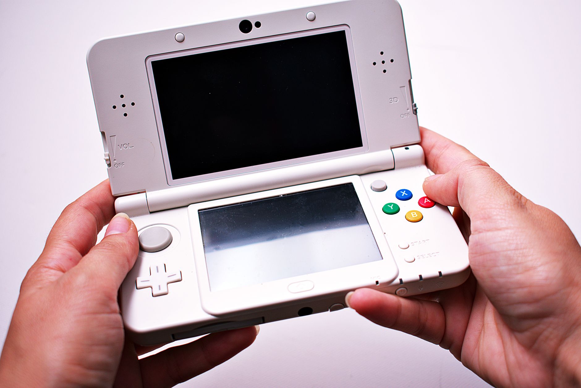 Close-up of a game controller prototype resting on a flat surface, showing a small rectangular display screen embedded in the center of the controller face, with visible hardware seams and unfinished plastic casing indicating a pre-production unit