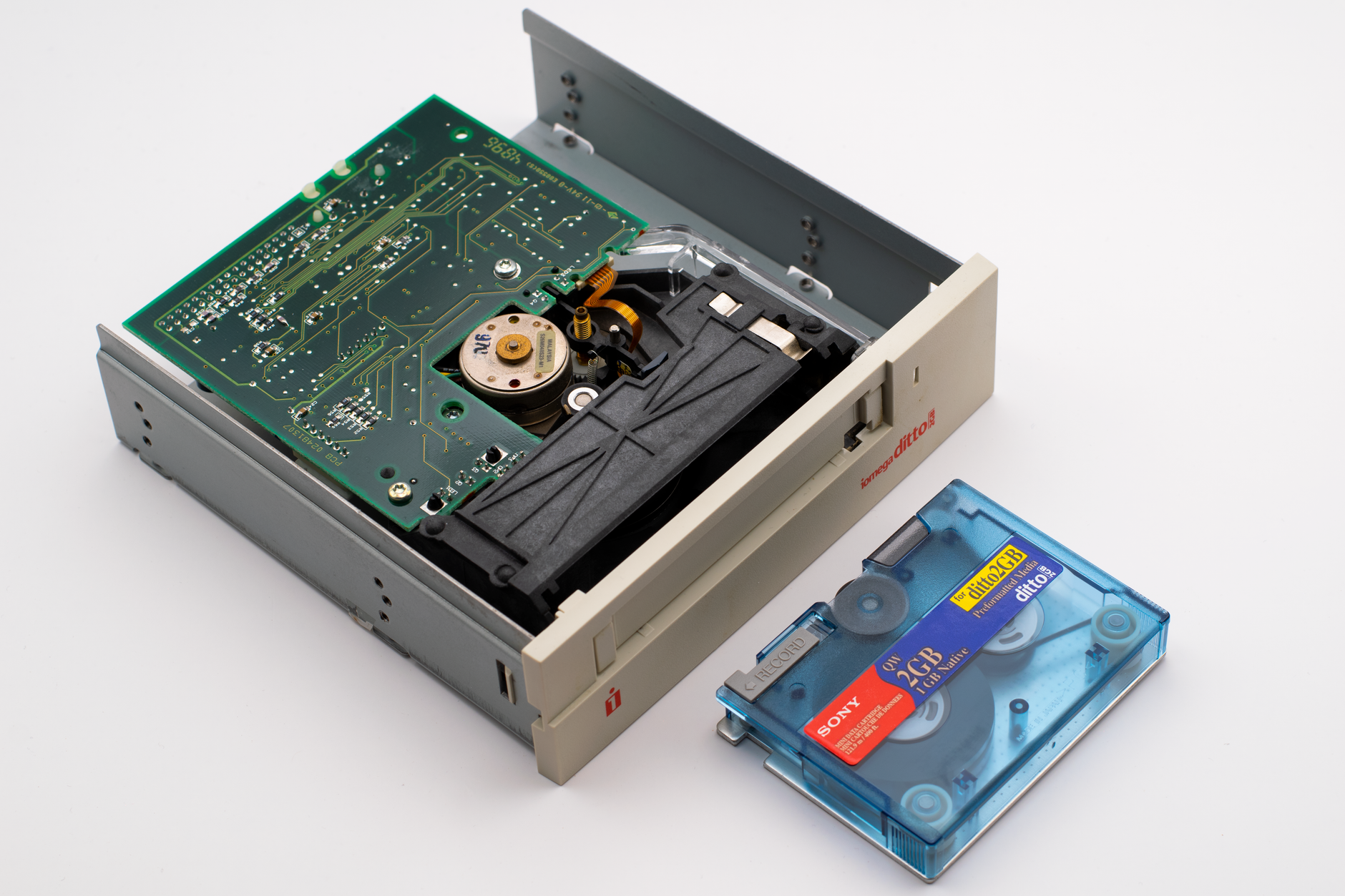 rows of game cartridge-style storage modules and cooling hardware inside an open electronics enclosure on a workbench, shot from a low angle