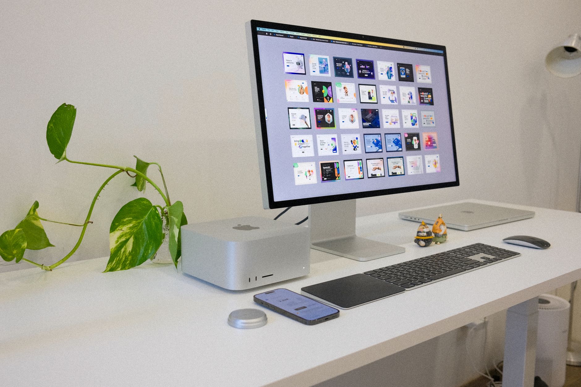 a 27-inch OLED monitor displaying a vibrant color gradient test pattern on a clean white studio desk, with no people in frame