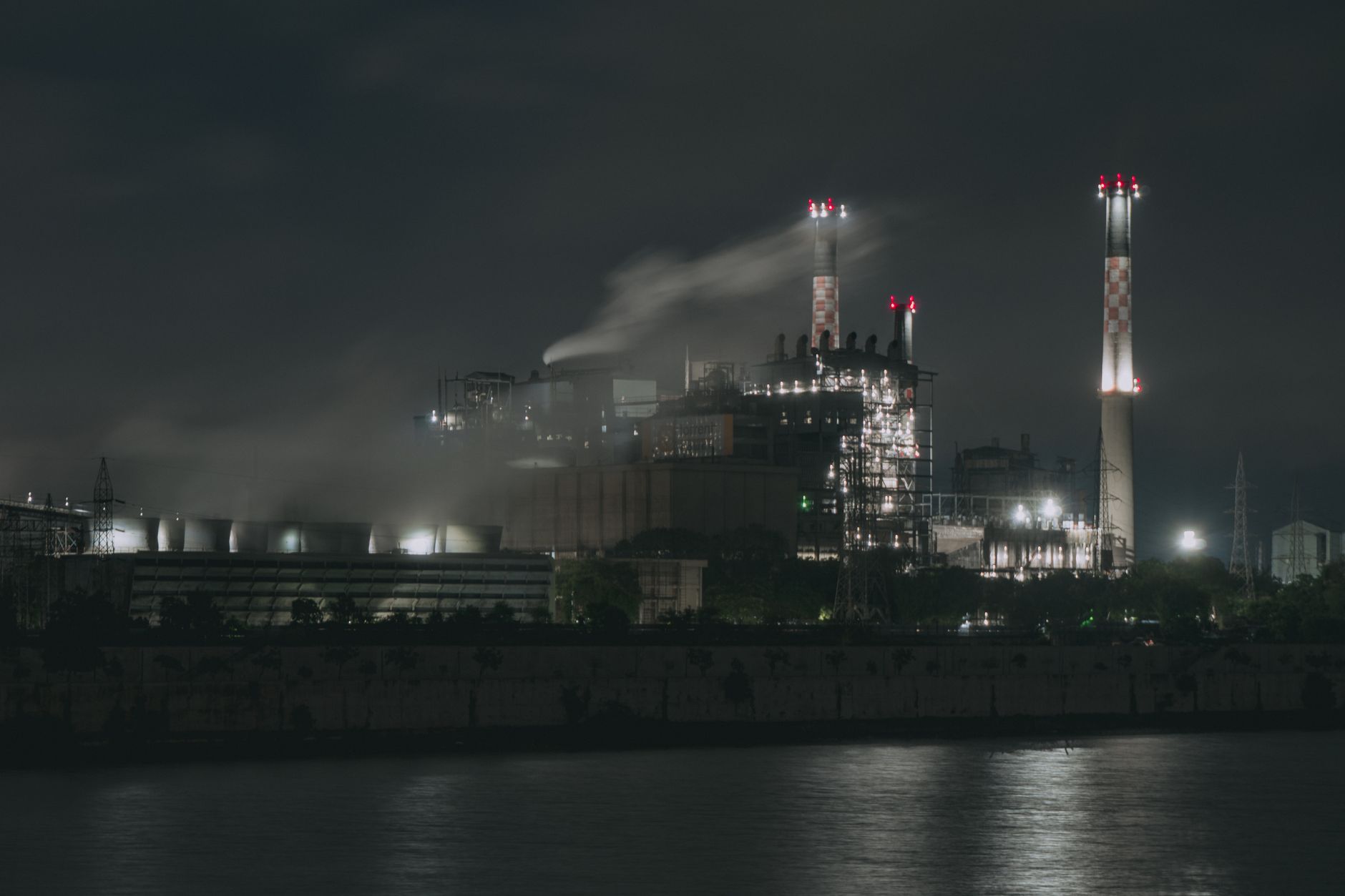 exterior of a large biopharmaceutical manufacturing plant surrounded by open land, with loading docks visible along one side