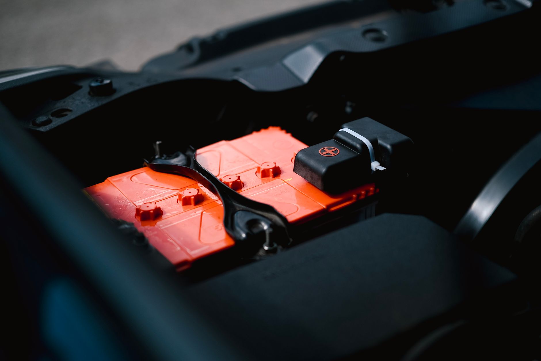 A close-up of a modern EV battery module array inside an open vehicle chassis on an assembly line, industrial lighting overhead