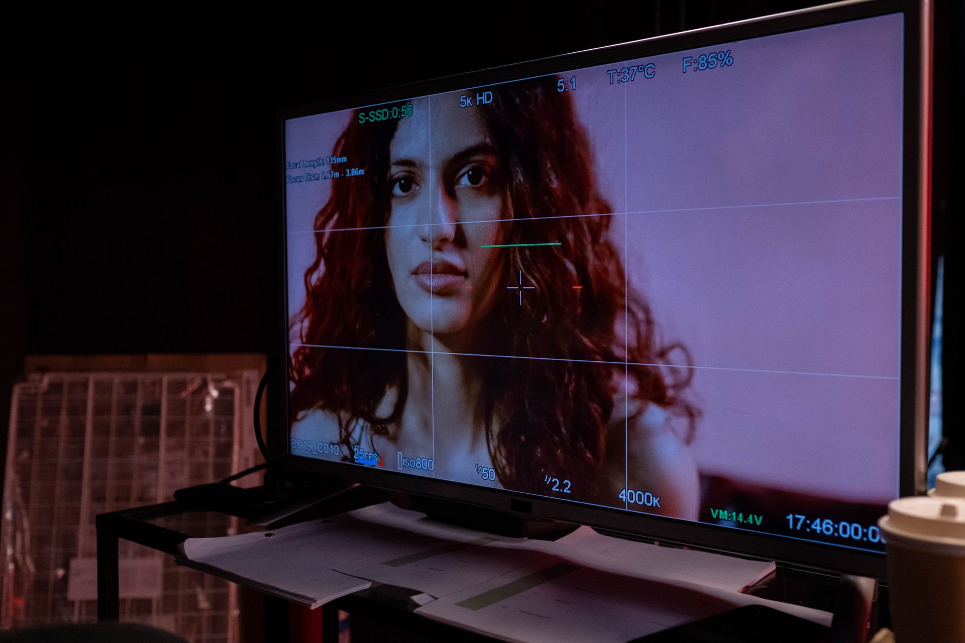 a wide shot of a television broadcast control room with rows of monitors displaying different camera angles of a dark studio stage