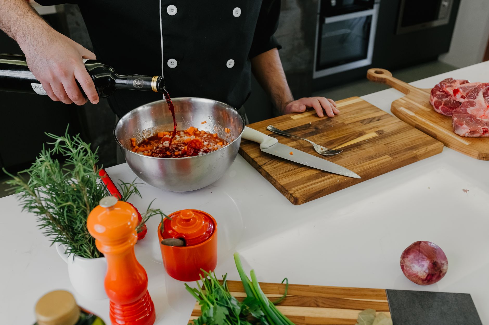 a wooden kitchen countertop with neatly arranged meal kit ingredients including fresh vegetables, measured spices in small bowls, and a printed recipe card