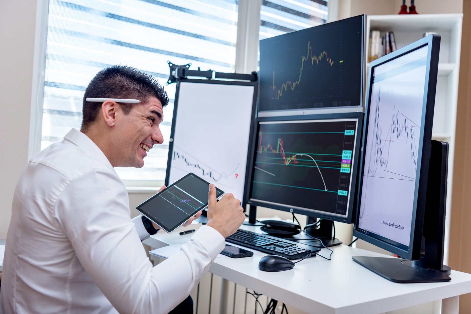 a wide-angle view of a modern open-plan office with multiple large monitors displaying data visualizations and personality profile dashboards, workstations arranged in clusters