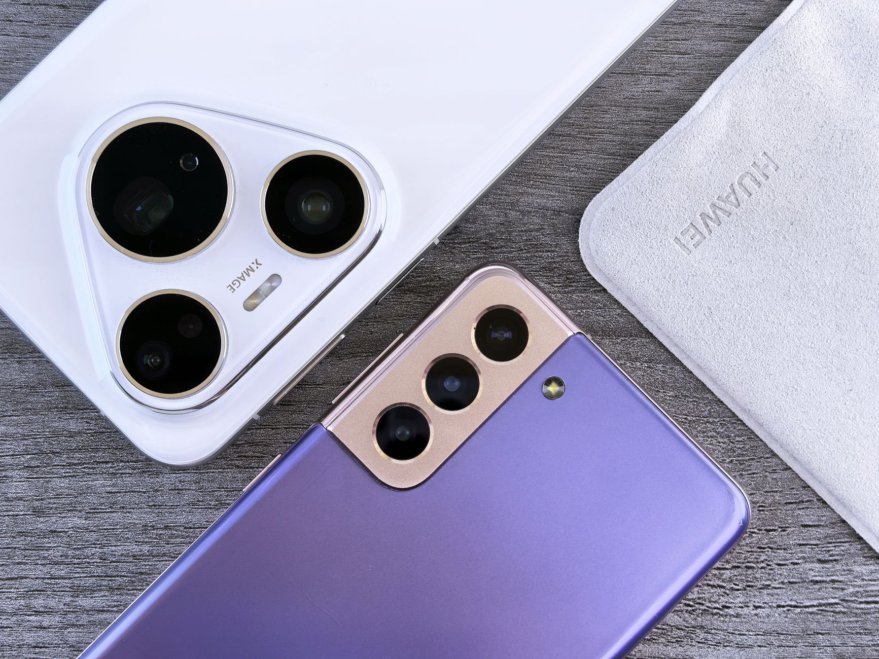 close-up of a smartphone camera module with multiple lenses visible, resting on a matte surface under studio lighting