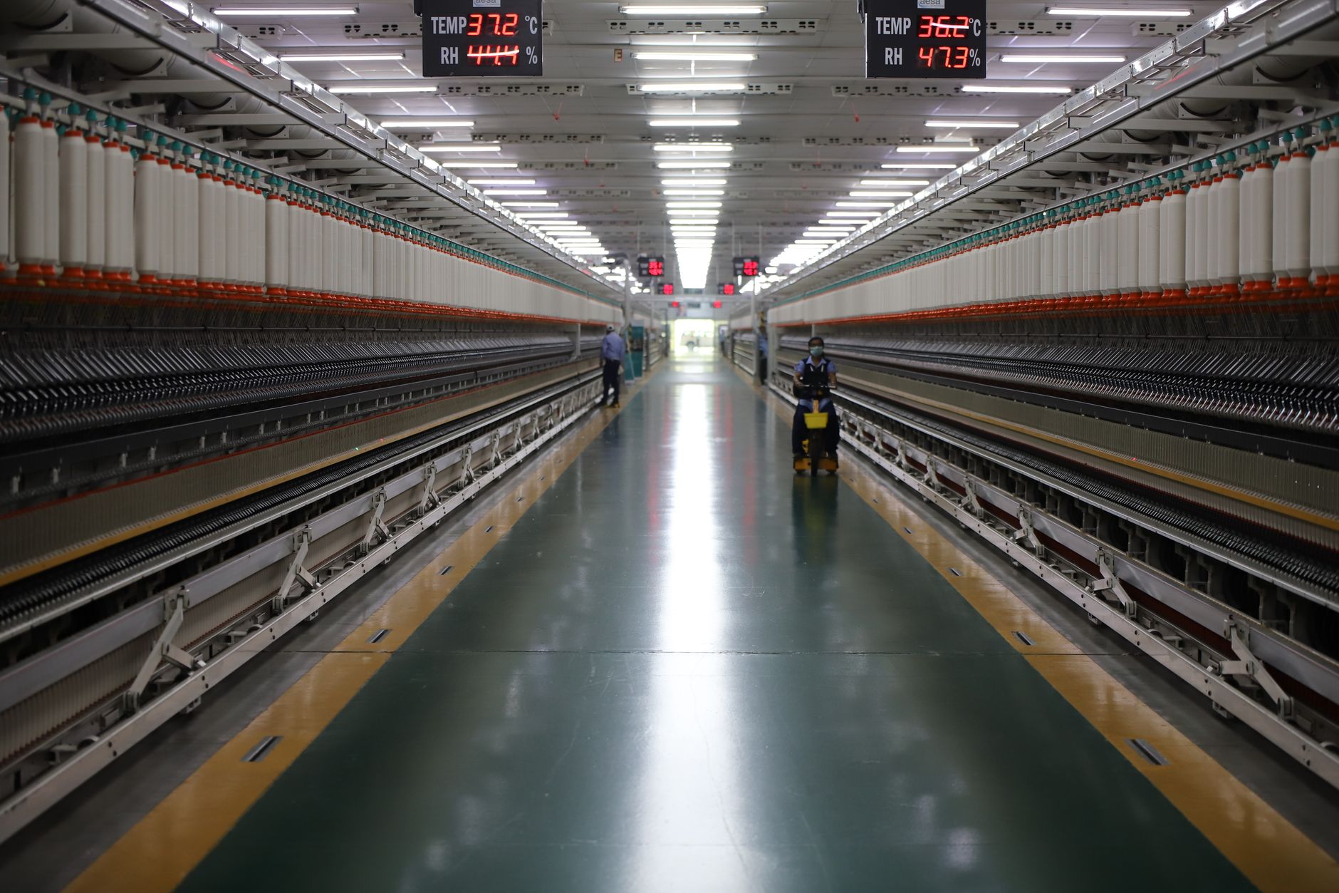 a wide shot of a semiconductor fabrication cleanroom with automated wafer-handling equipment visible along the production line