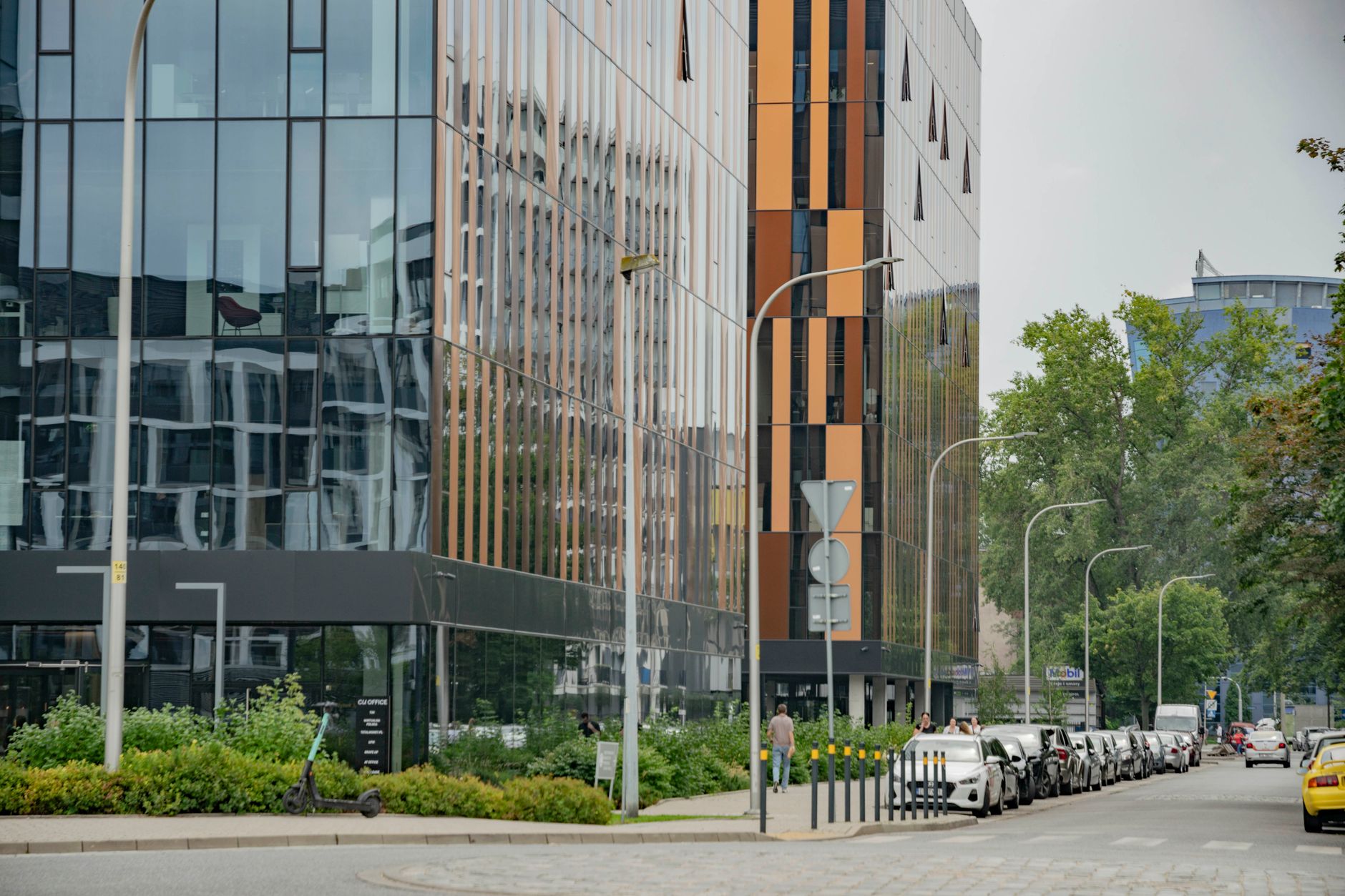 aerial view of a modern technology park campus with glass office buildings surrounded by greenery, shot at midday